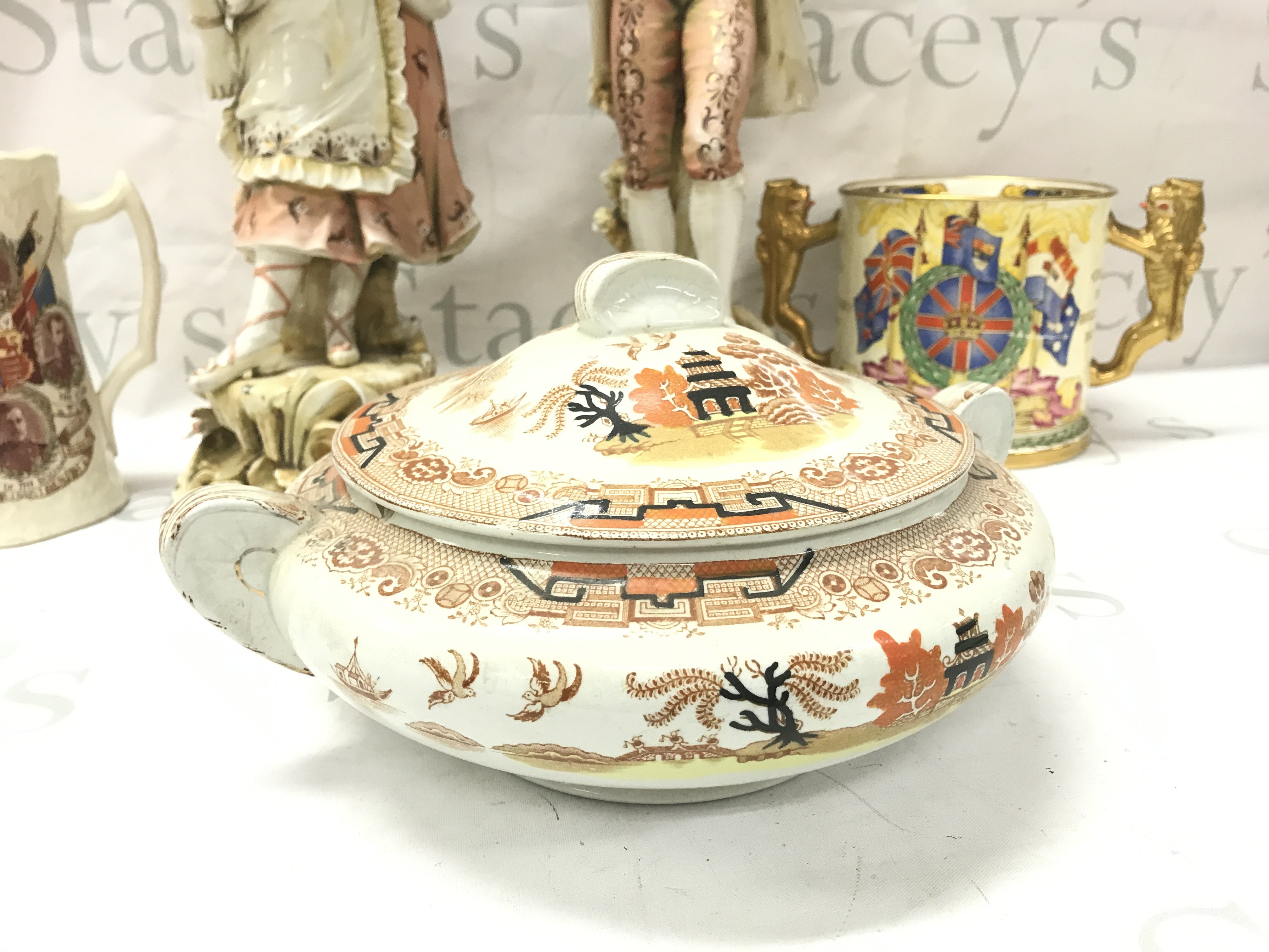 Two classical couple porcelain figures, Queen Victoria figure, Commemorative cups (twin handled by Paragon), Derwent Gibsons tureen . This lot cannot be posted. NO RESERVE