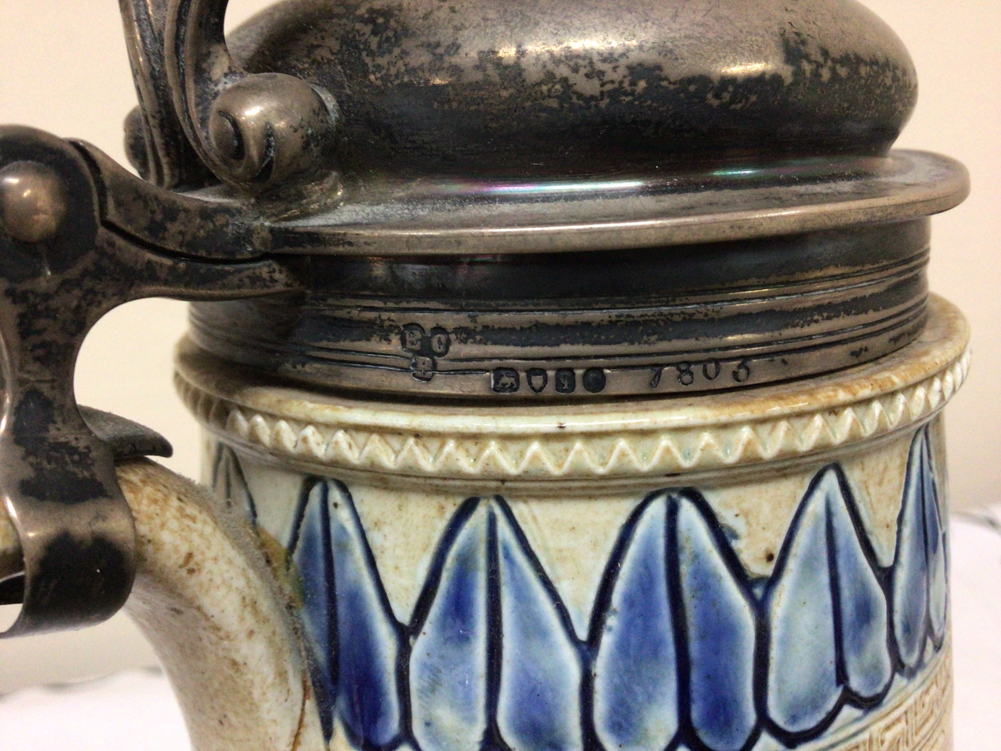 A Lambeth Doulton Victorian stoneware jug with a silver hinged top the sides with horses and a repeat pattern boarder. damage to the handle Hight 26cm marks to the base. NO RESERVE