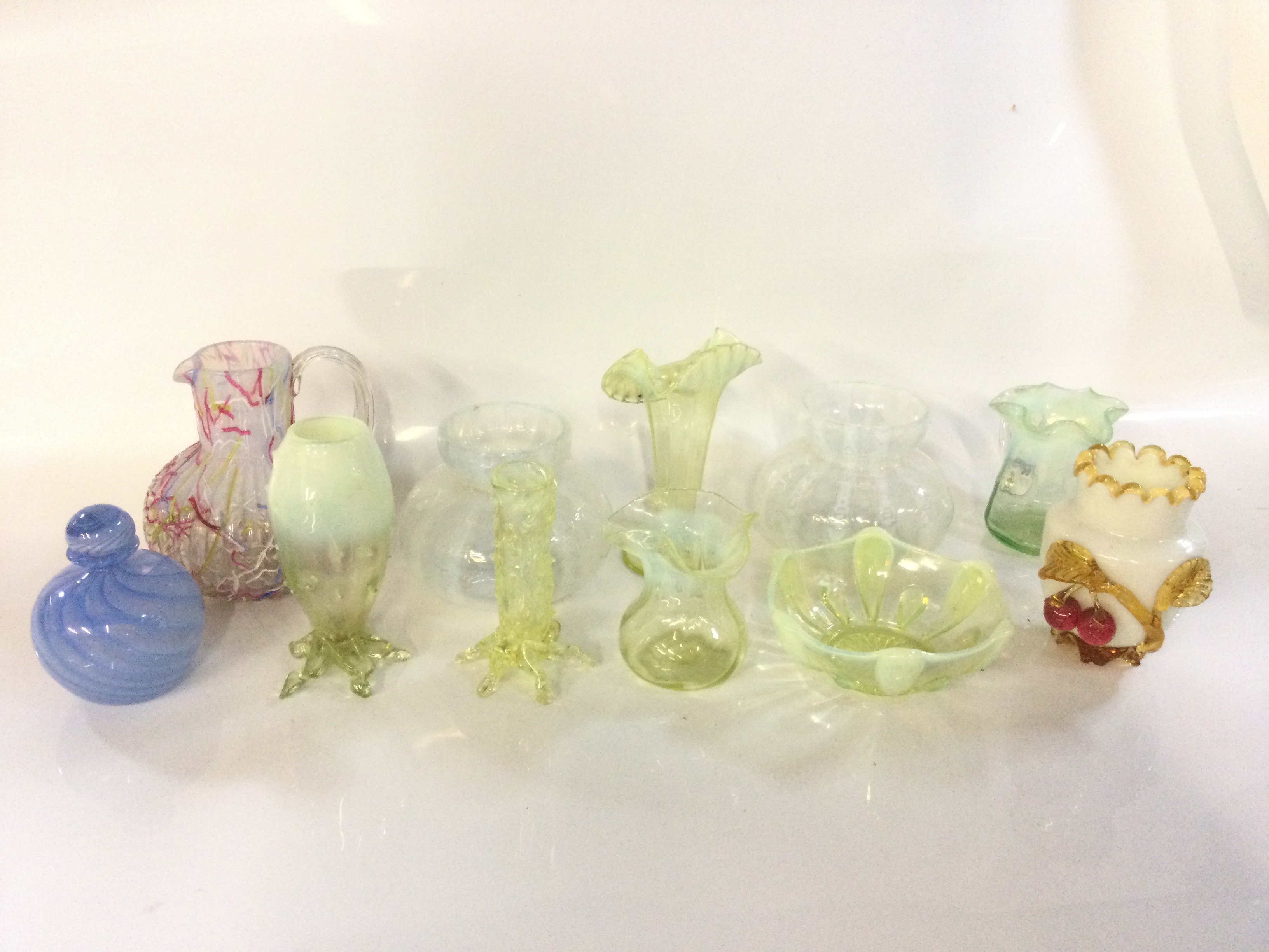 A collection of eleven pieces of Victorian Vaseline and uranium glassware vases and a dish.
