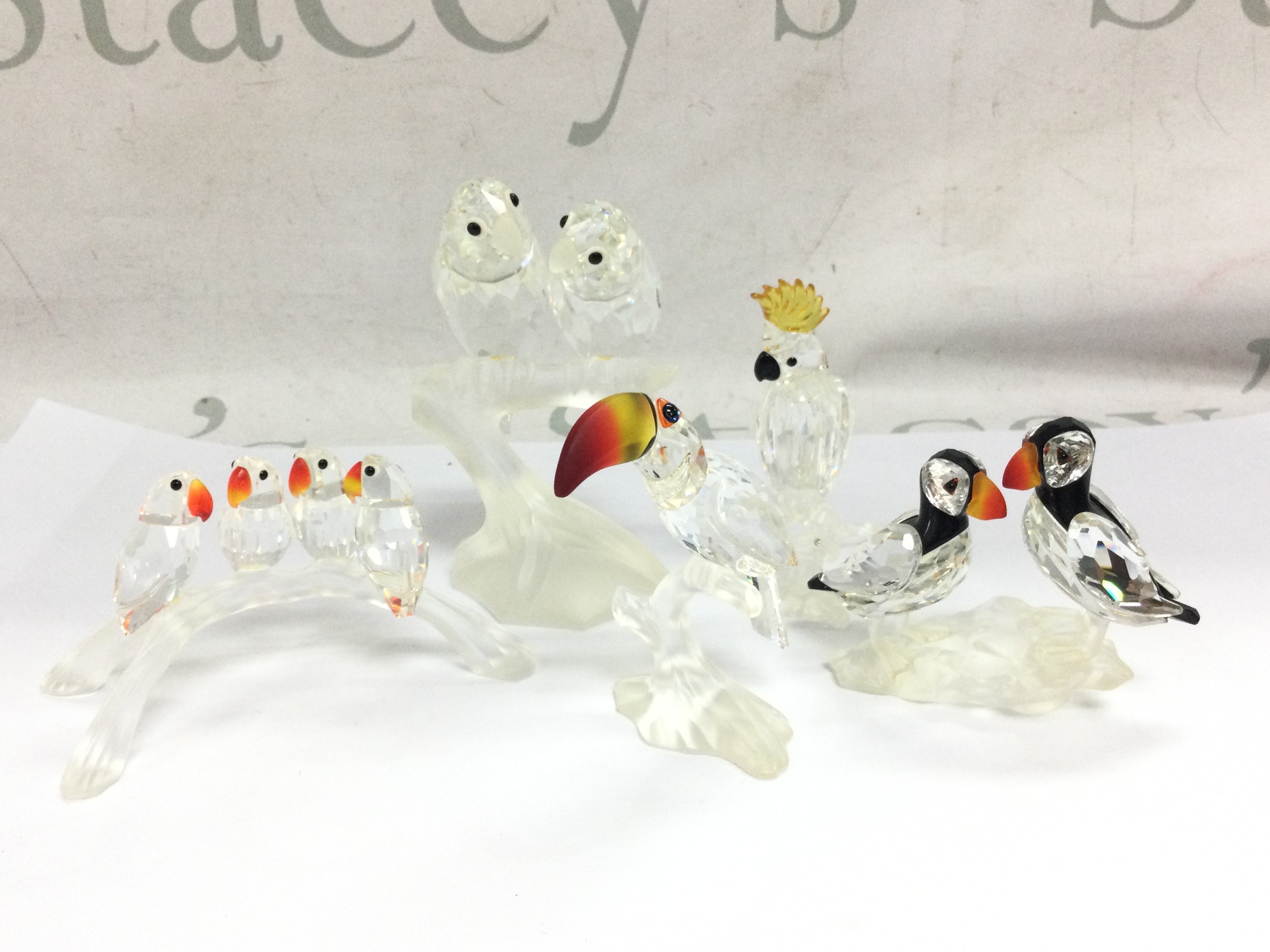 A collection of Swarovski crystal glass figures including Love Birds, Toucan, Puffins etc . This lot cannot be posted