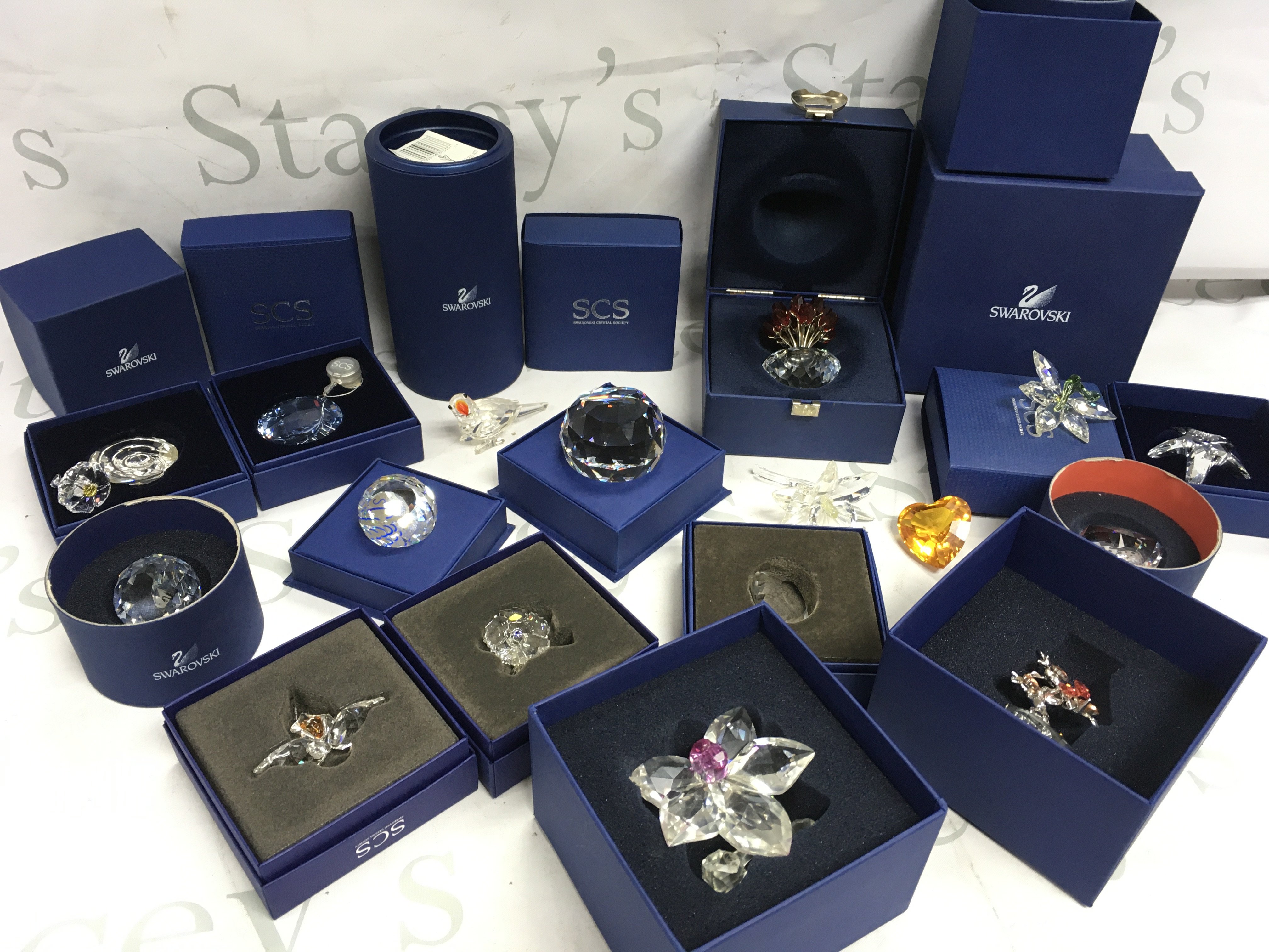 A collection of Swarovski Crystal glass ornaments including Orchid Blossom, Farewell to Concorde paperweight, vase of roses, bonsai rhodium , Parrot . This lot cannot be posted