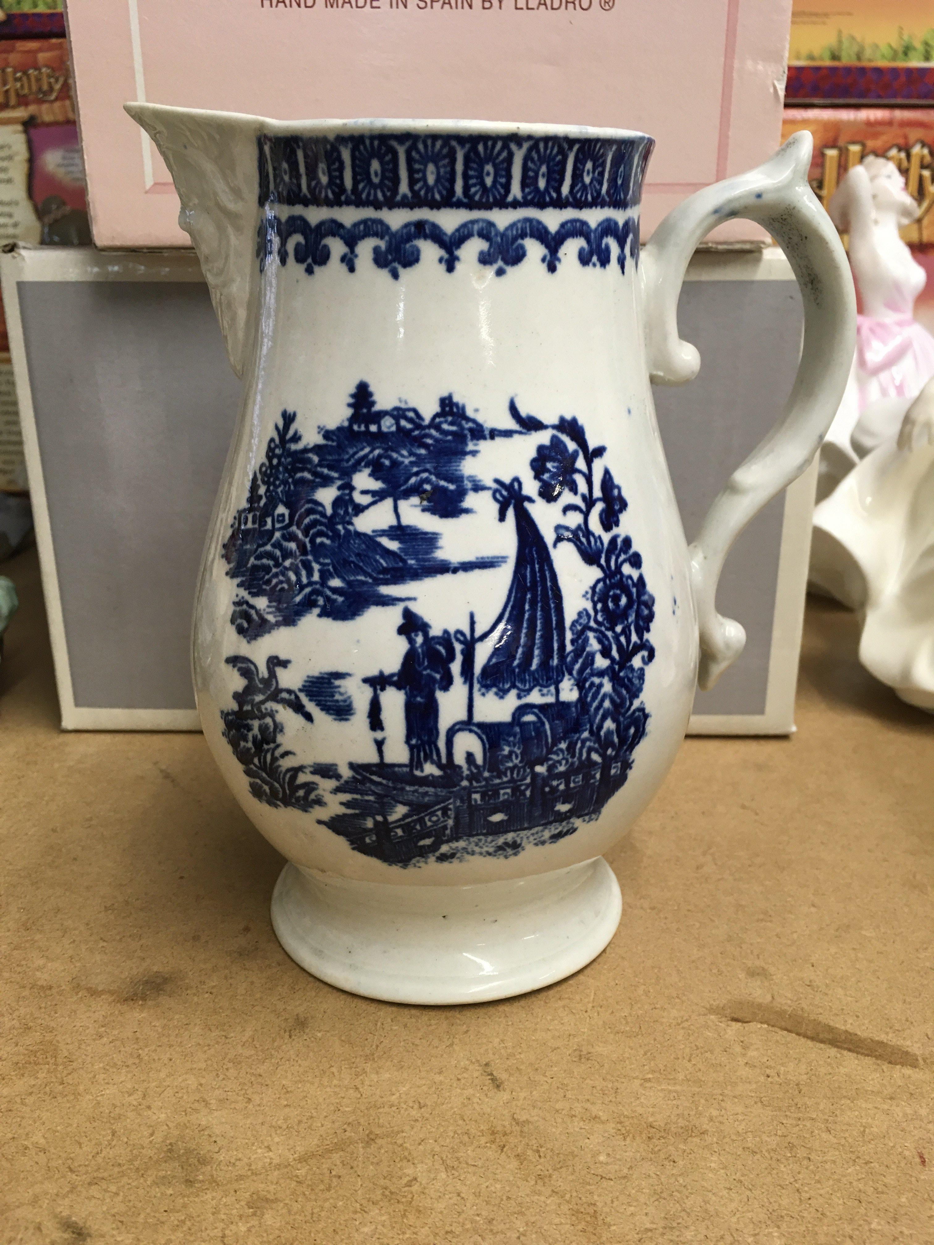 A Liverpool blue and white jug decorated in the fisherman pattern.