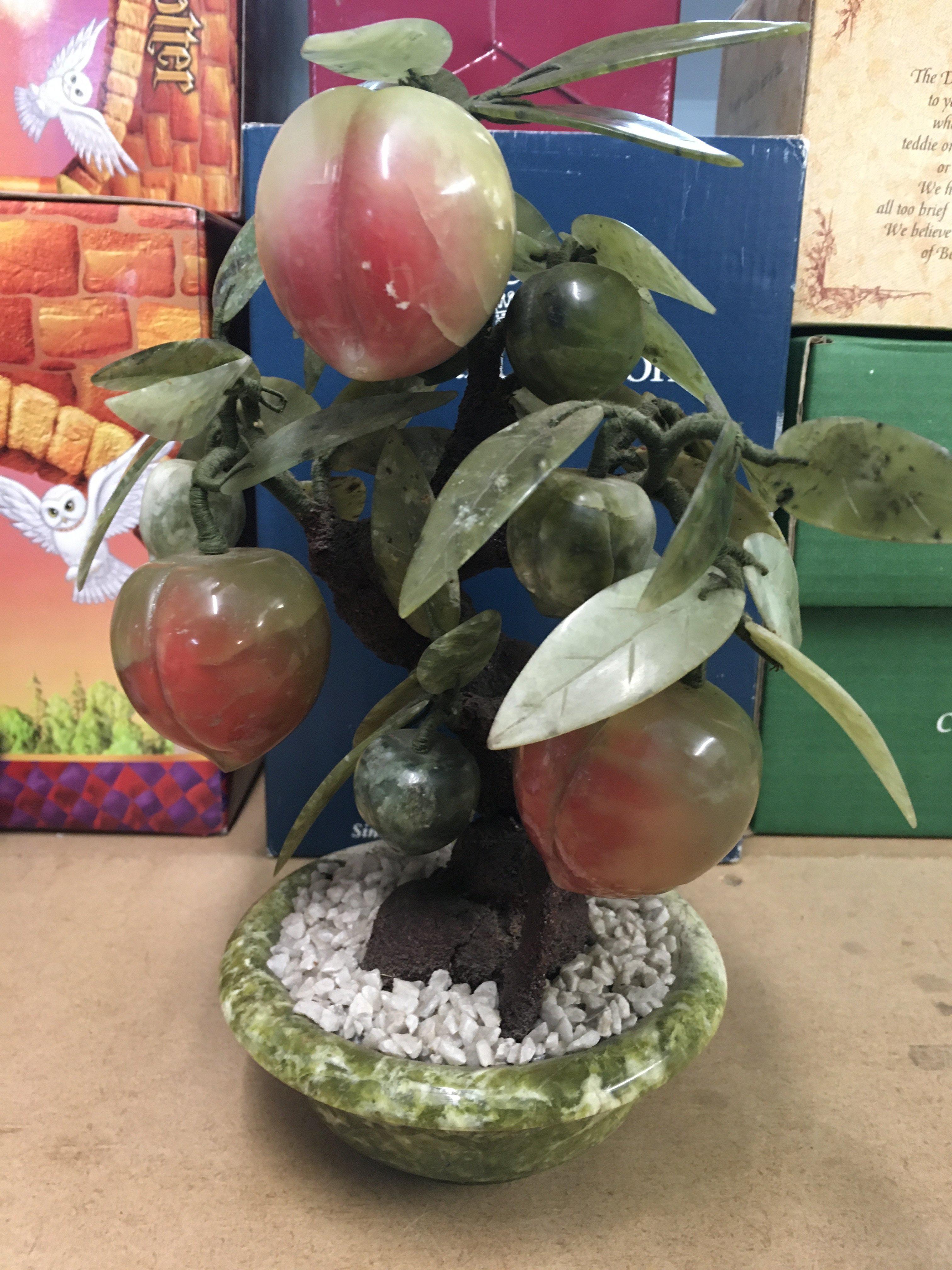 A Chinese hard stone carving in the form of a tree of life .