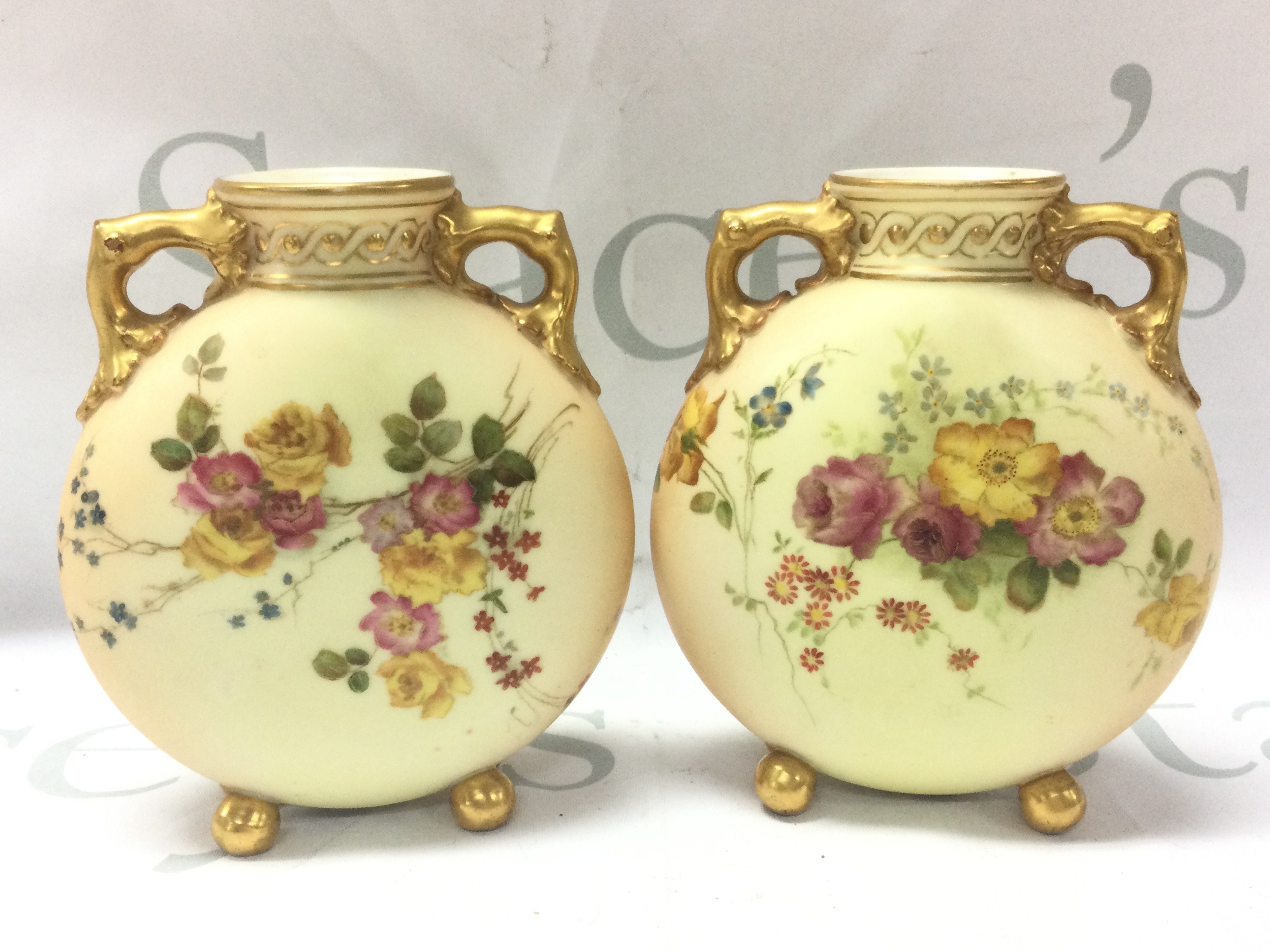 Royal Worcester Blush Ivory moon flash style porcelain vases with floral decoration, gilt handles and feet . 11cm wide 13cm tall. This lot cannot be posted