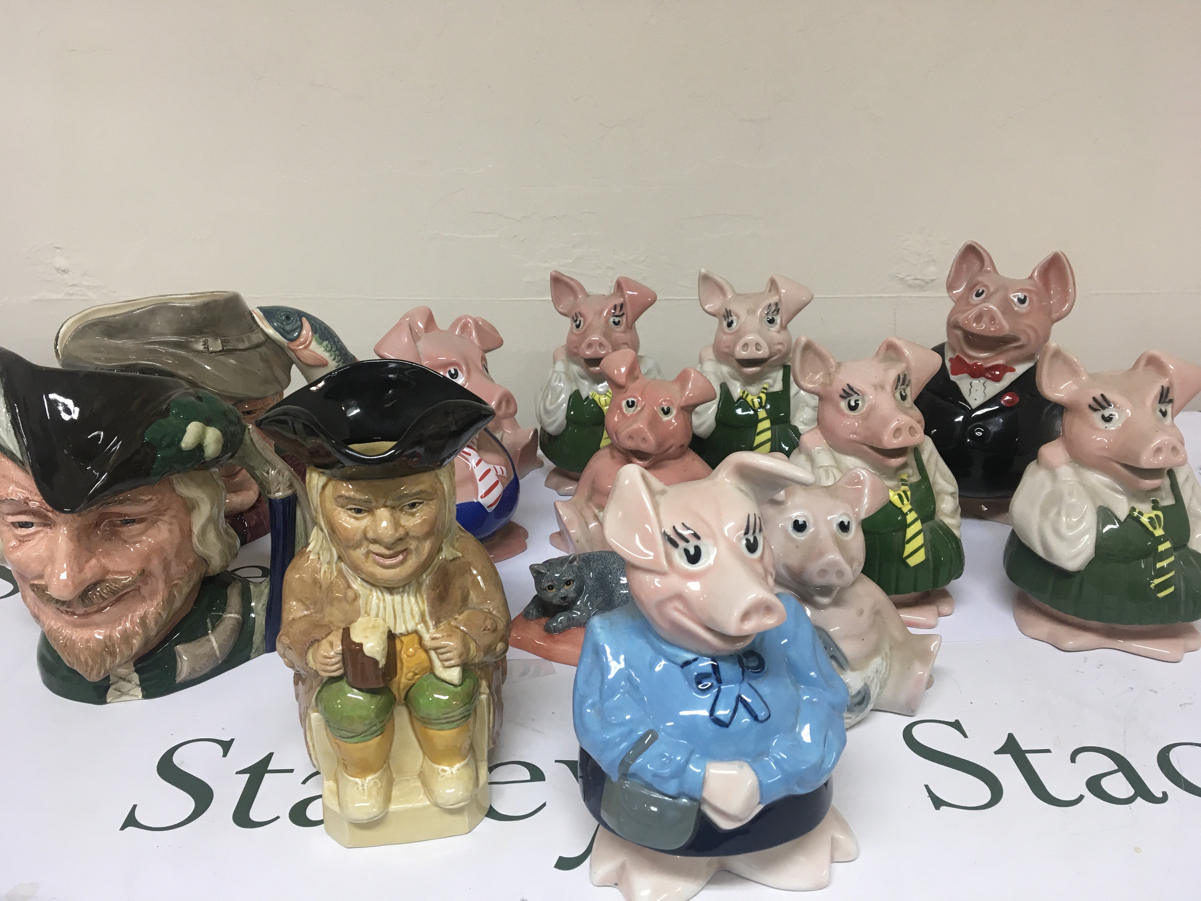 A collection of NatWest Pig money boxes Doulton caricature jugs and other ceramics.