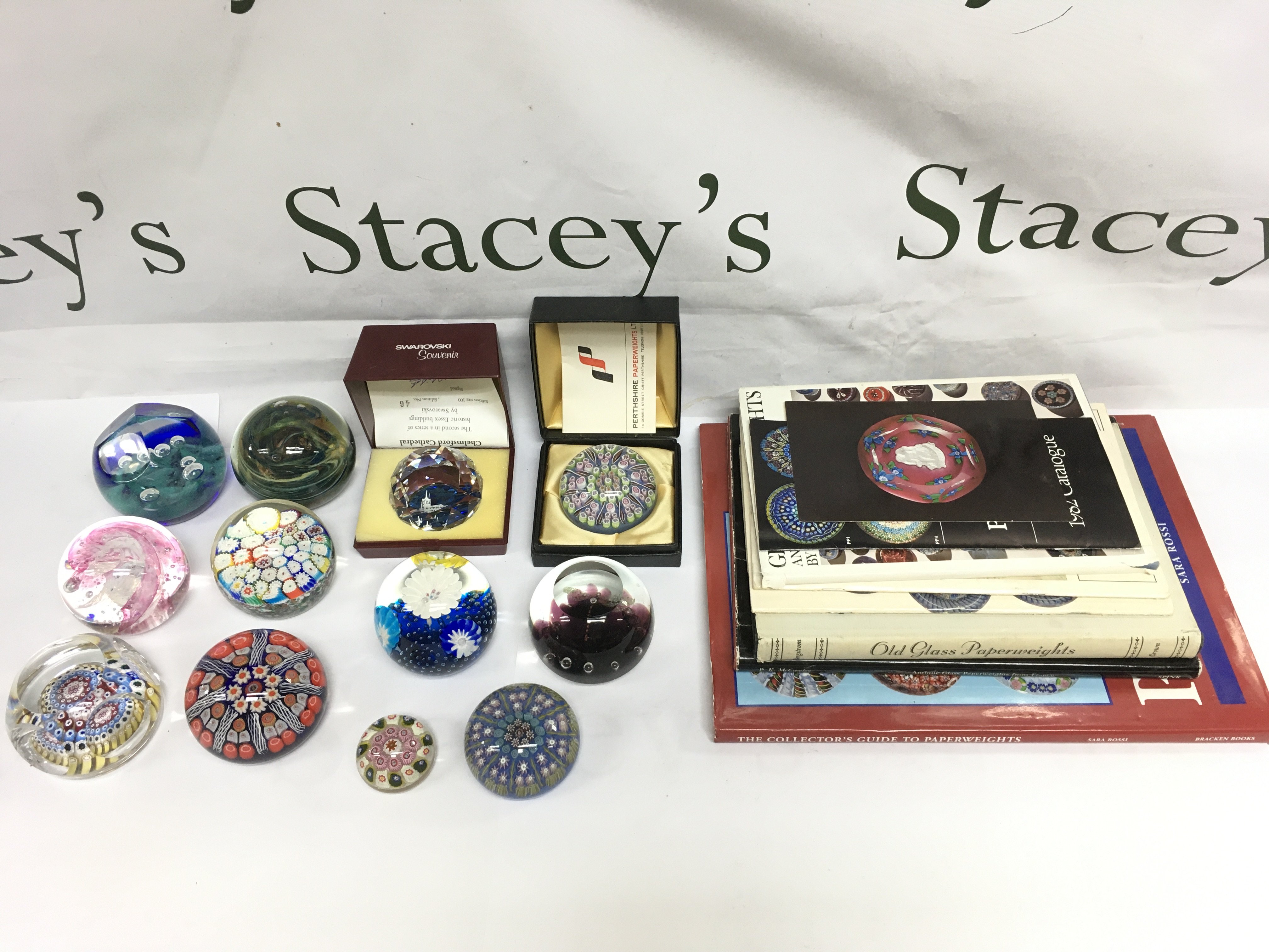 Twelve paperweights including Perthshire, Caithness and others plus some paperweight collector's books. Shipping category D.