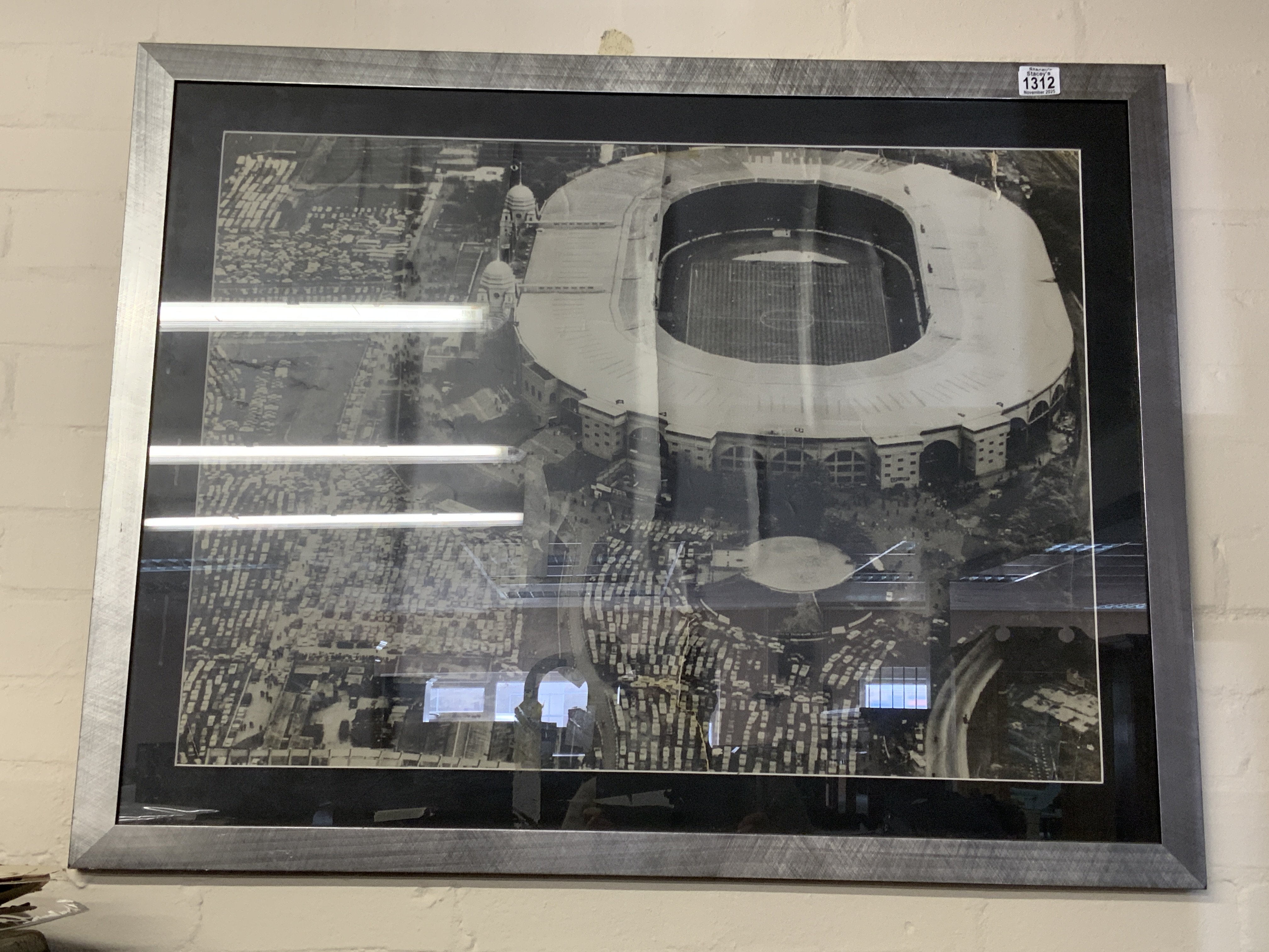 A large framed photo of Wembley Stadium c.1970s (some damage) .98cm x 76cm- NO RESERVE