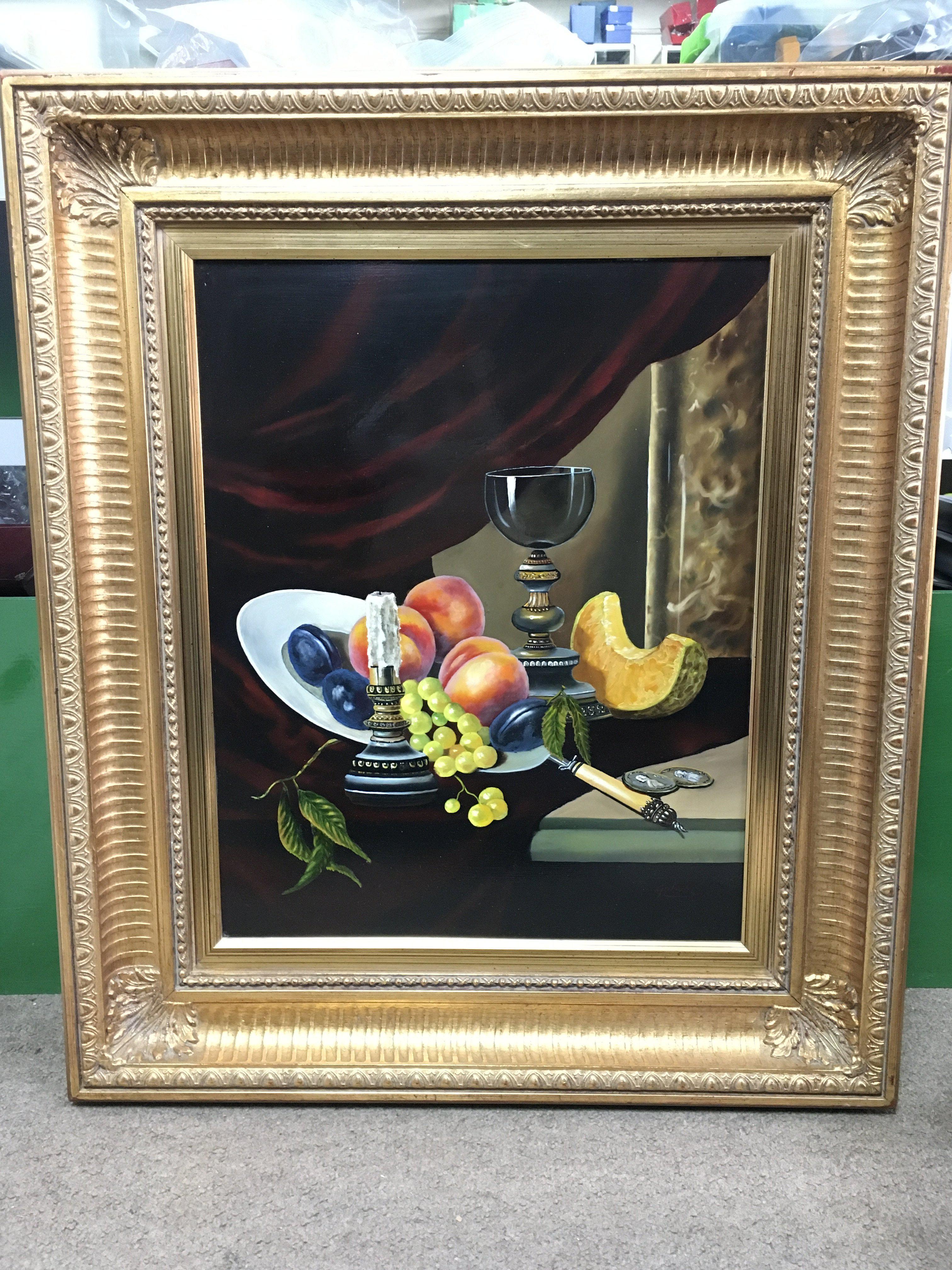 A 20th century gilt framed still life oil painting by T Gabris, depicting fruits and a goblet. Frame dimensions 61x70cm
