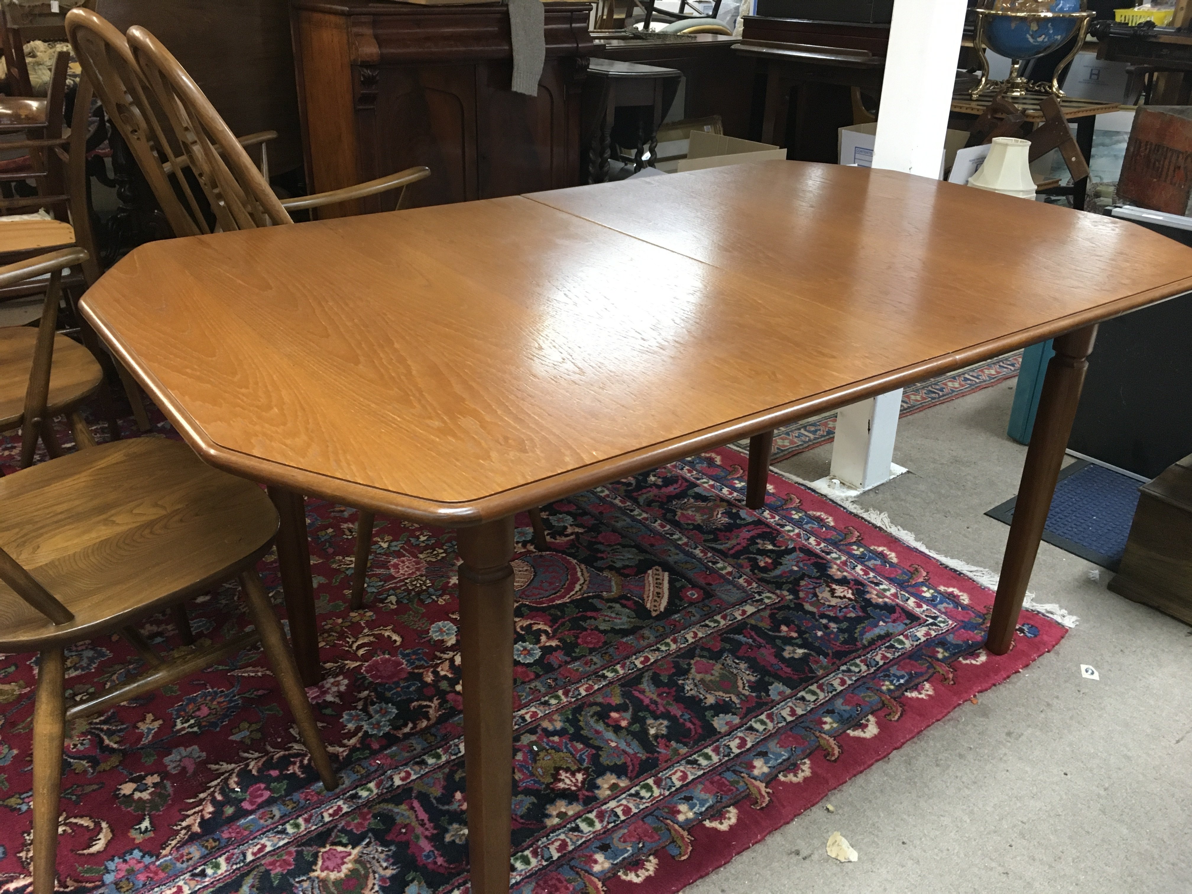 A mid century teak extending dining table and four swan back ercole chairs. Dining table dimensions 148x92cm.