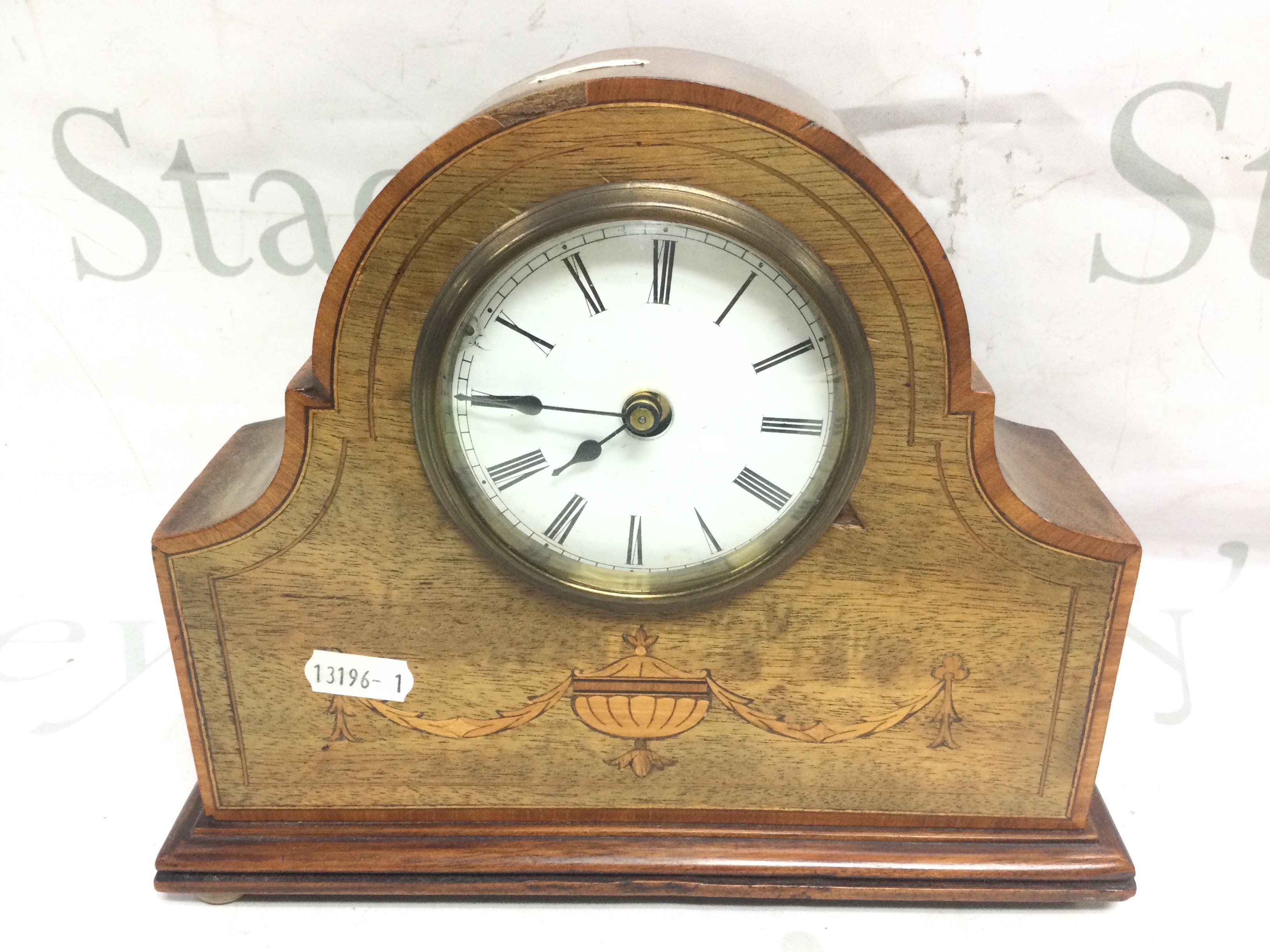 An Edwardian mantle clock with a French movement , inlaid design and key . Seen working. Dimensions 25 cm tall 21 cm wide. This lot cannot be posted