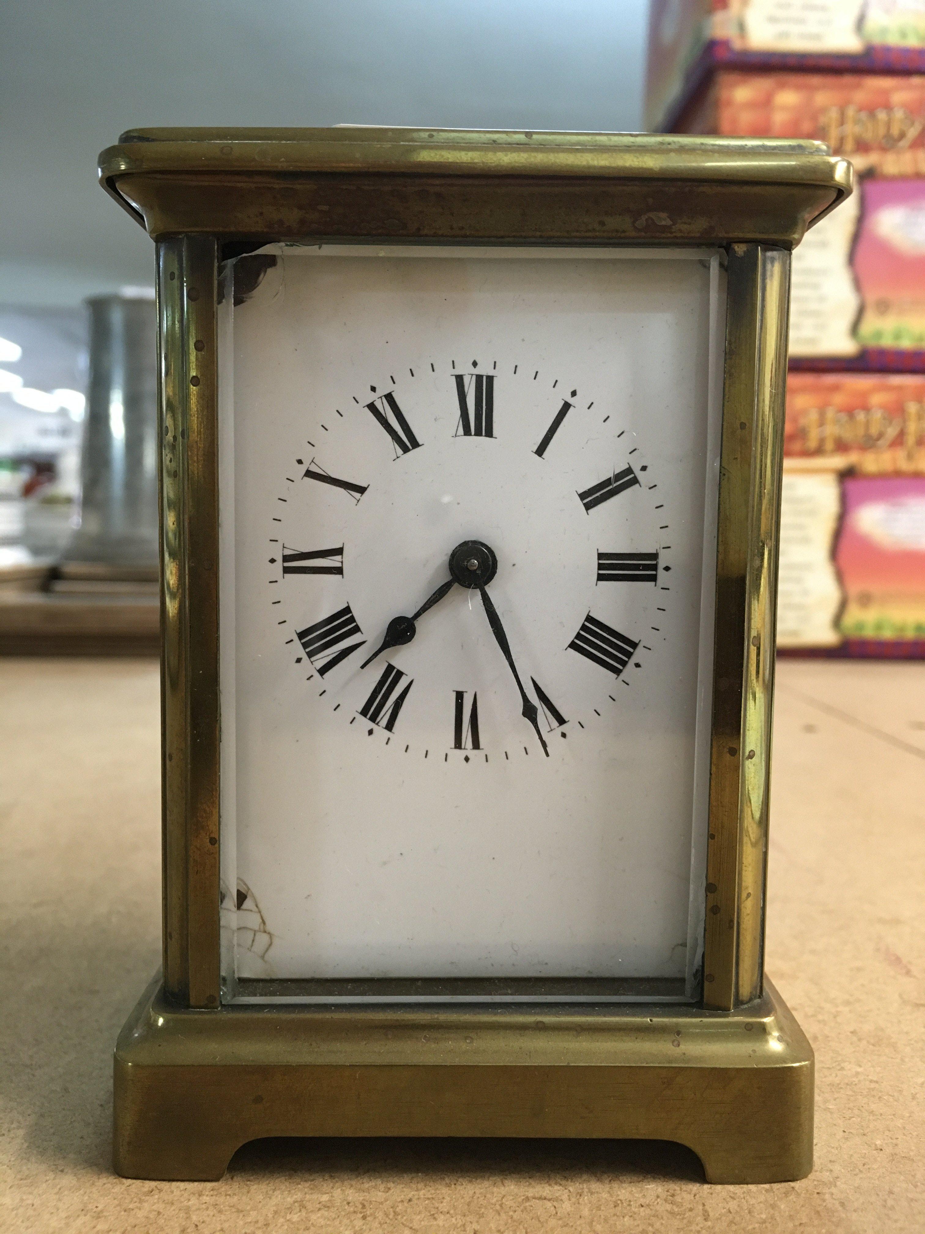 A brass case carriage clock, the enamel dial with Roman numerals