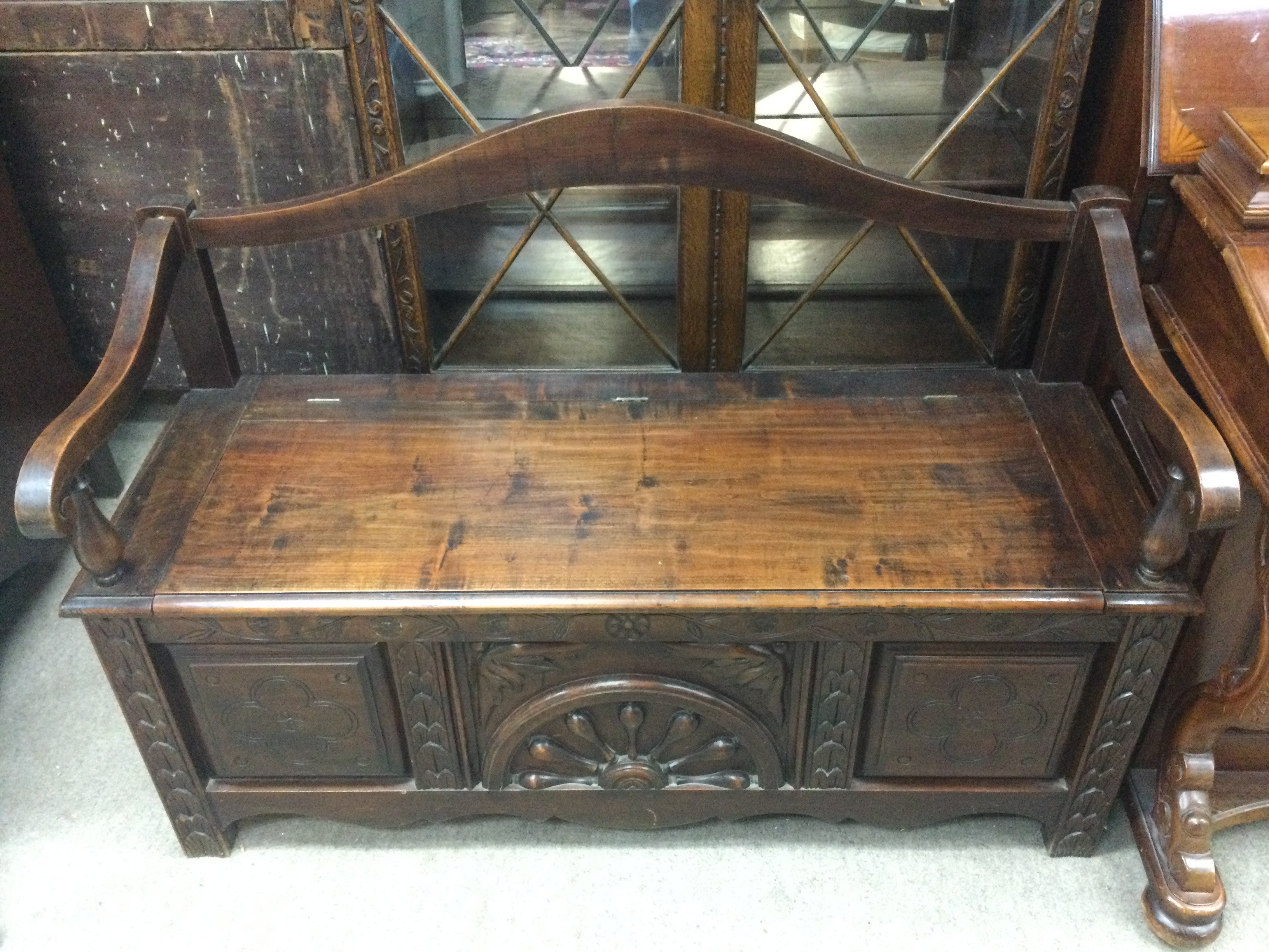 An Oak settle with carved design . Dimensions 122cm wide 85cm tall