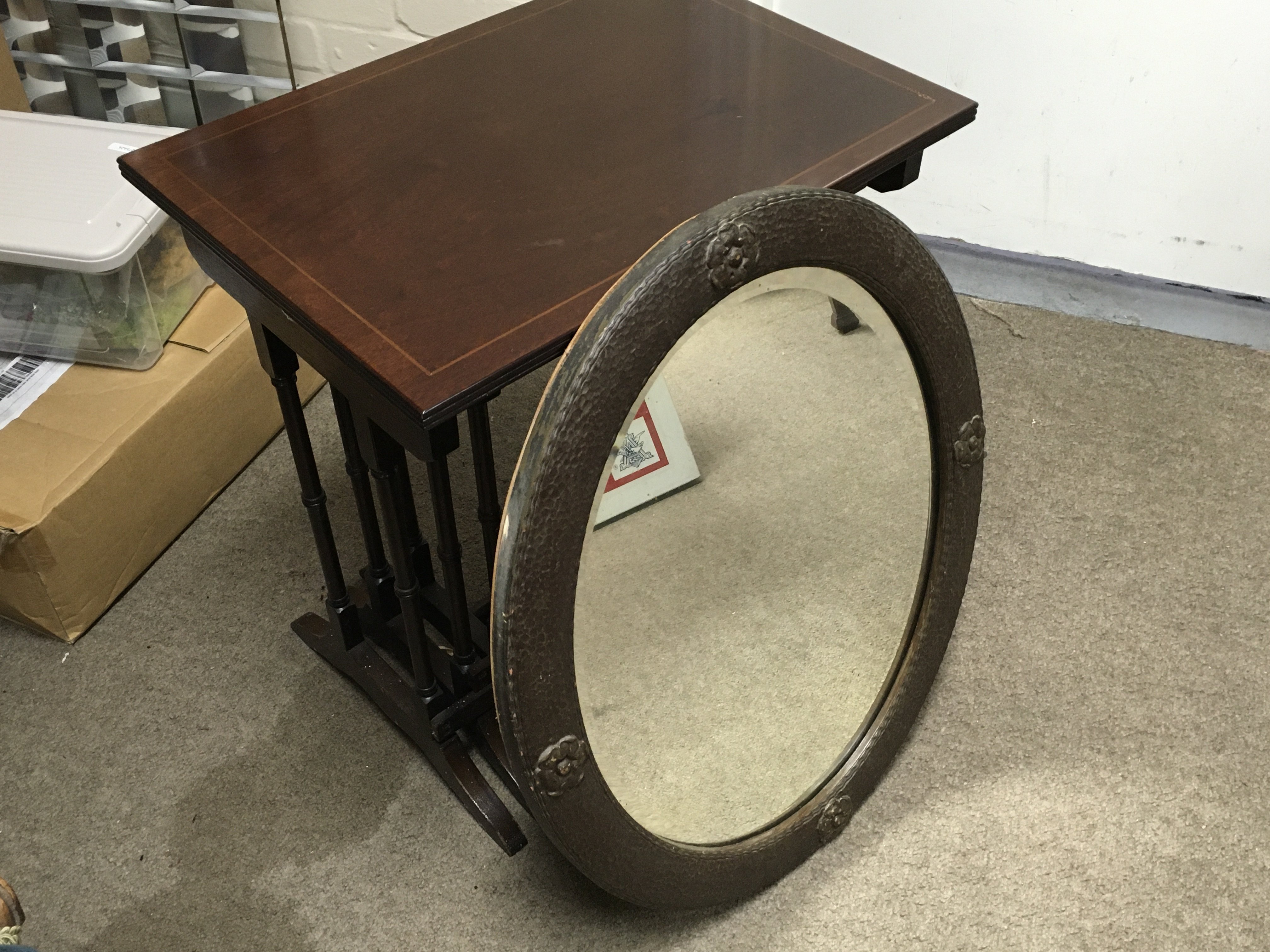 An oval oak framed wall mirror with a nest of mahogany tables. 54cm tall 52cm wide