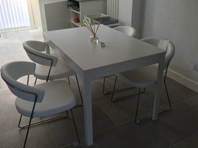 A set of four modern white faux leather and steel kitchen chairs. (4)