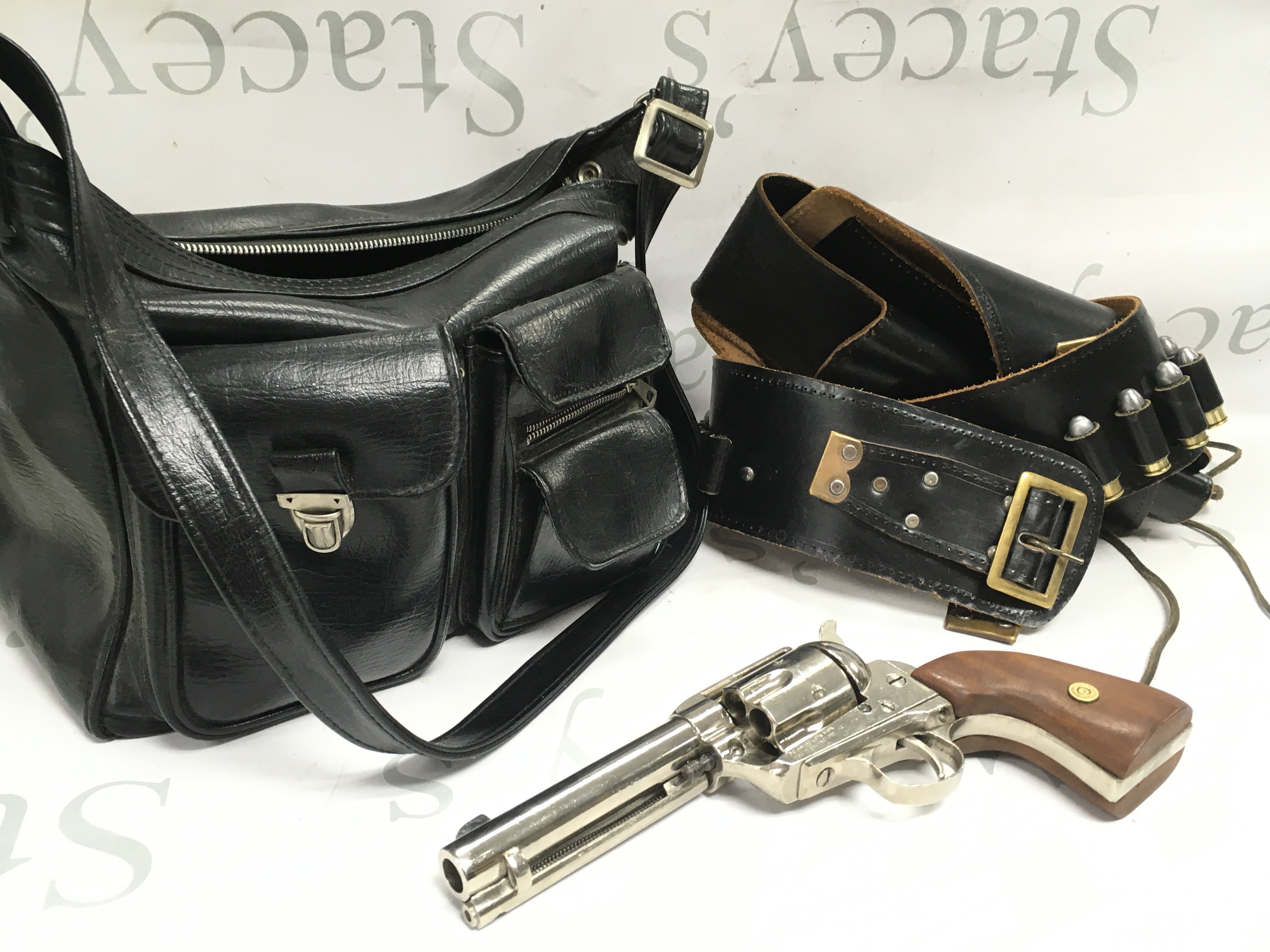 A replica blank firing MGG maker colt revolver in a leather holster