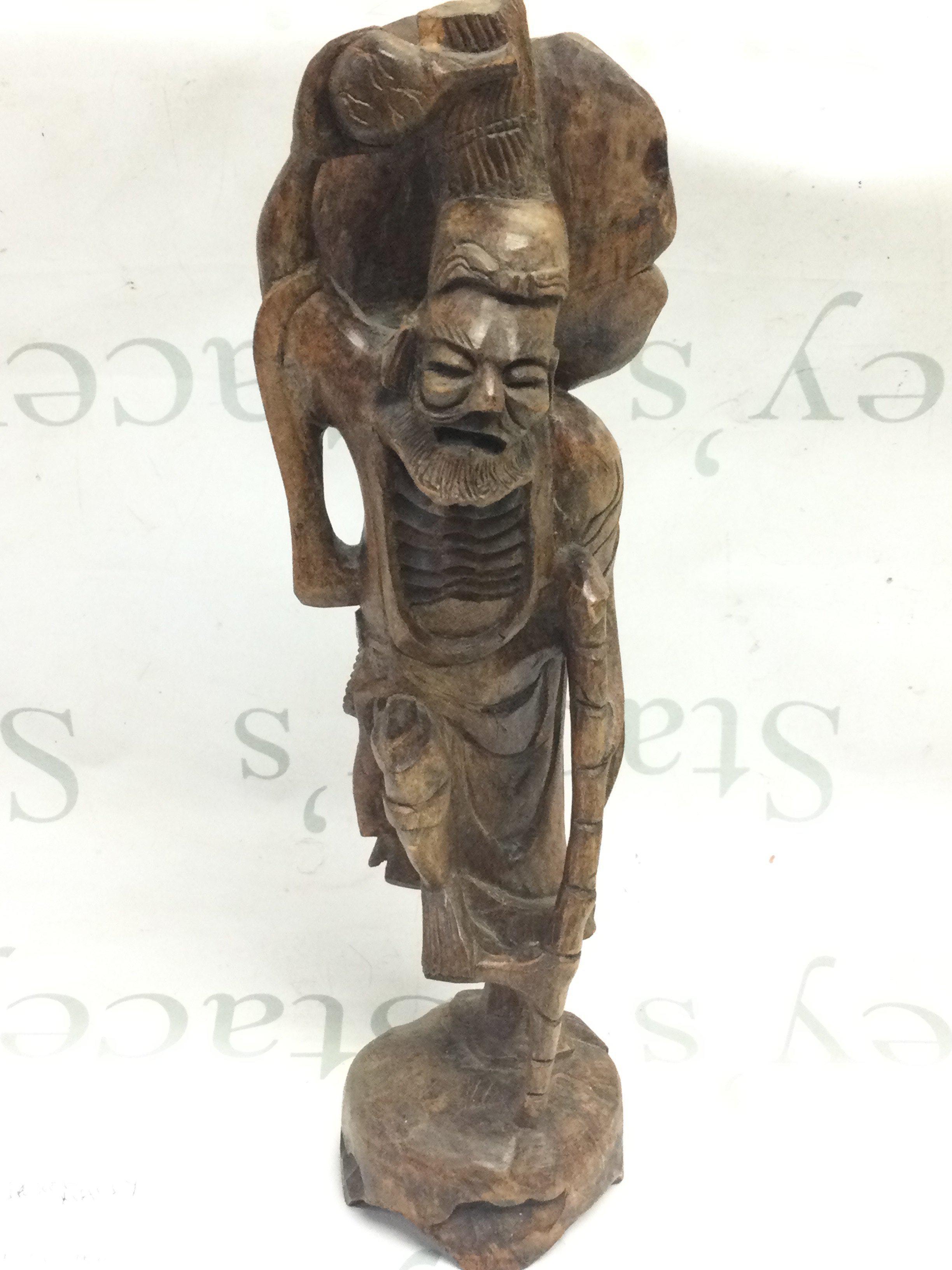 An unusual carved wooden figure with stick 43cm tall approximately . Postage category c
