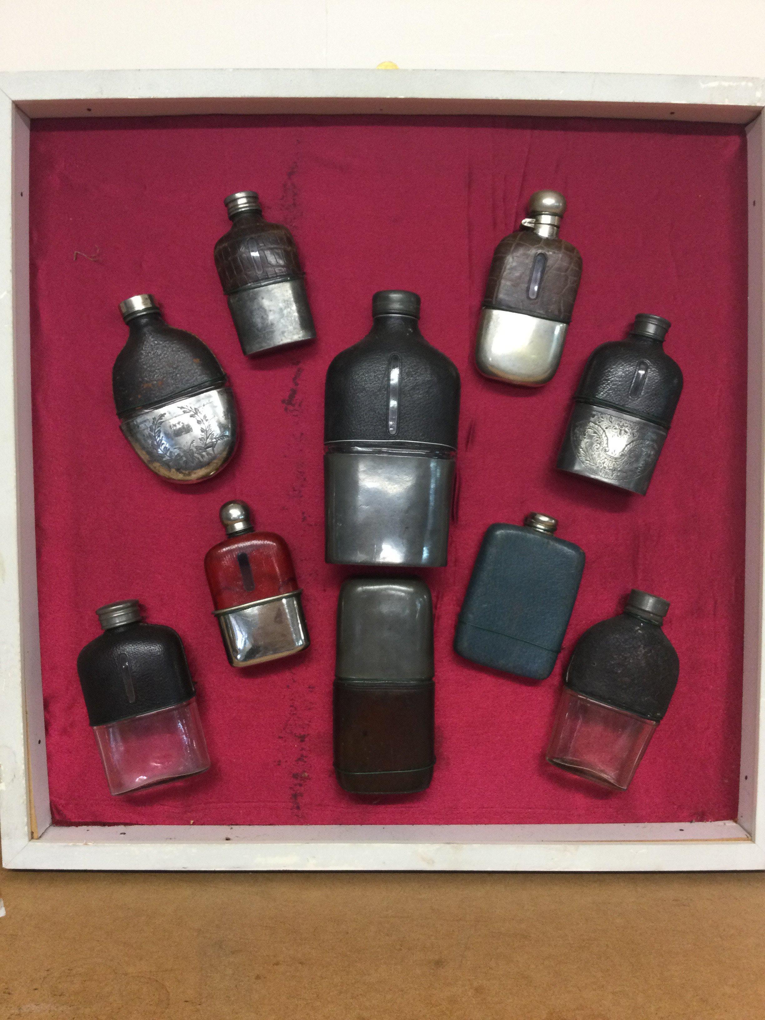 a good mounted and framed collection of ten Victorian and vintage hipflasks . This lot cannot be posted
