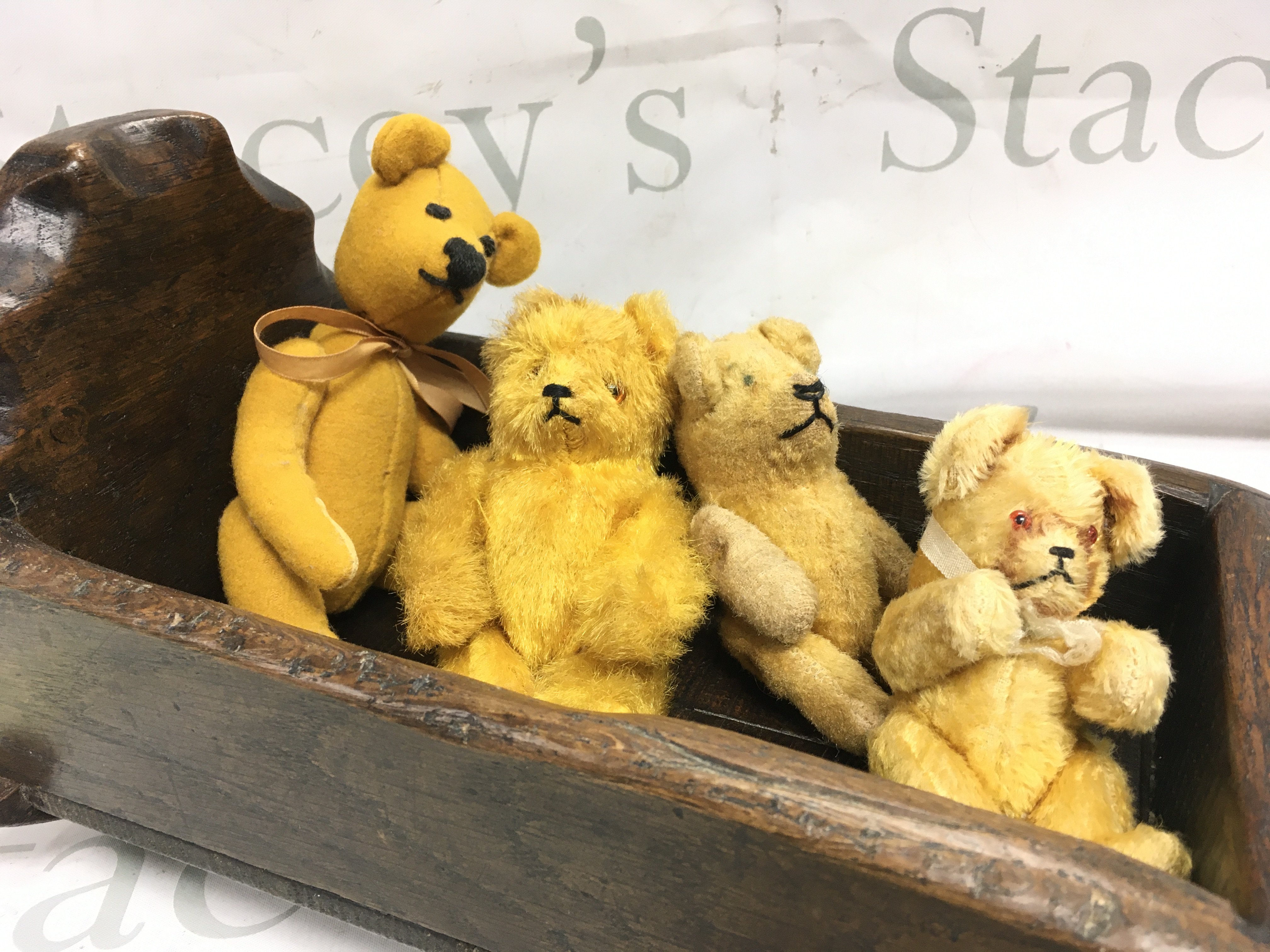 Four vintage miniature jointed teddy bears in an old hardwood rocker, signed on one foot. Postage category b