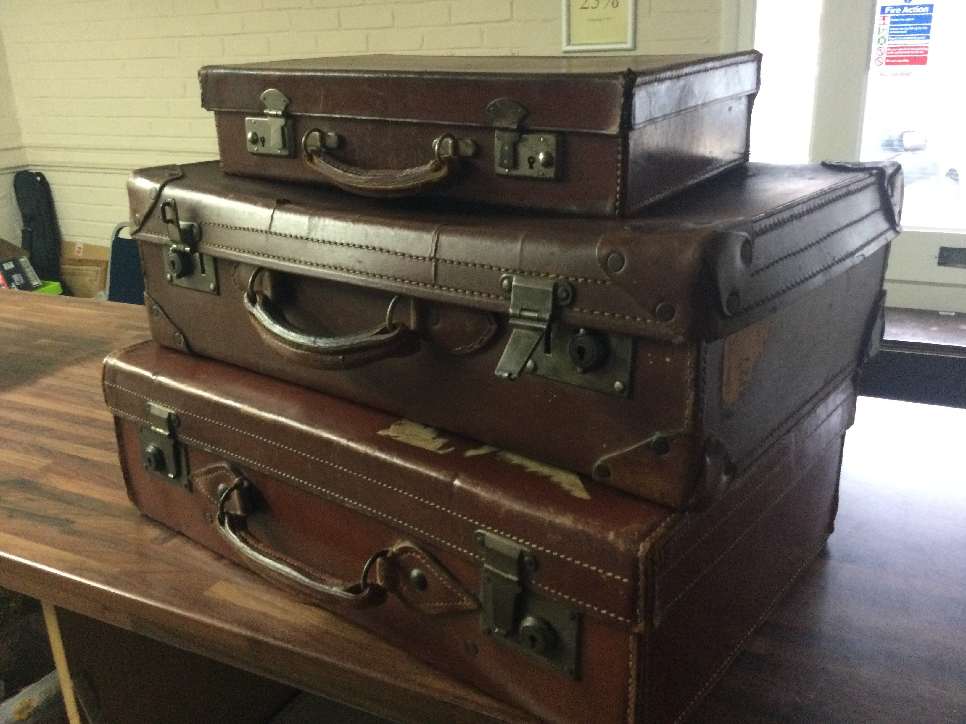 Three vintage leather suit cases . This lot cannot be posted