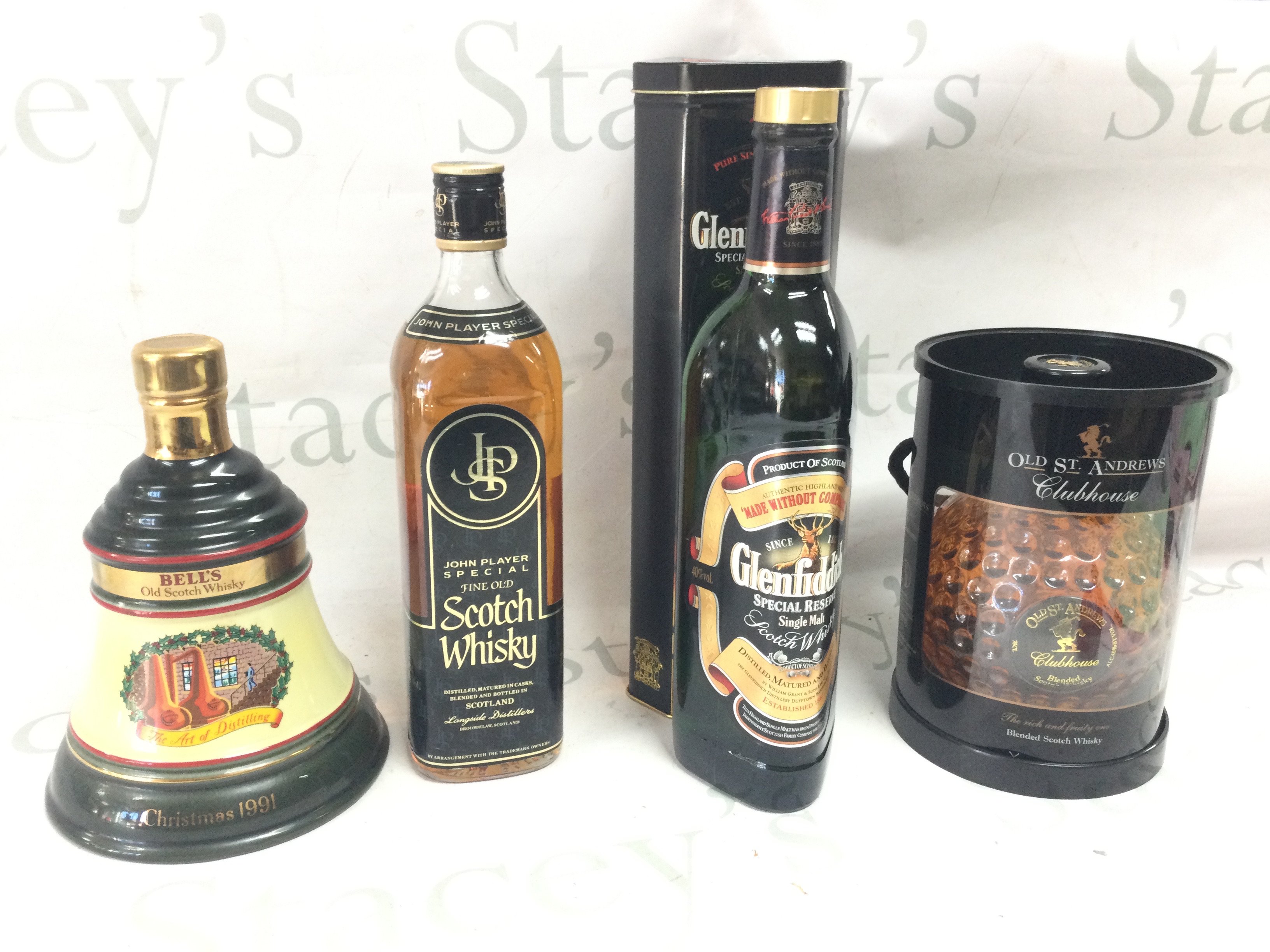 Four whiskeys - Bells Christmas 1991, John Player Special scotch, Glenfiddich Single Malt Scotch, Old St Andrews Clubhouse blended scotch. This lot cannot be posted