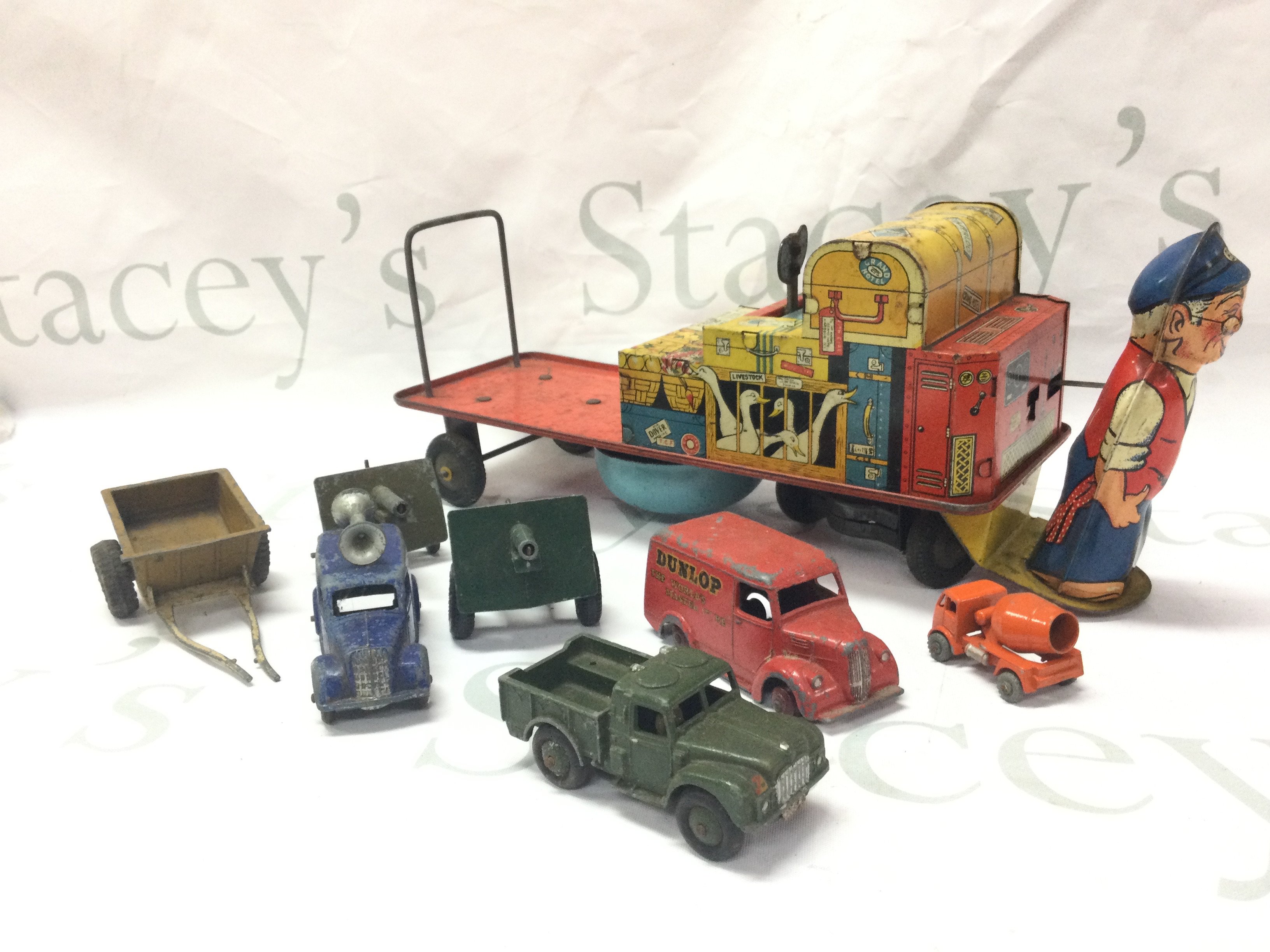 A collection of vintage toys including a tin plate Mr Porter and luggage , various play worn dinky toys . Postage cat B