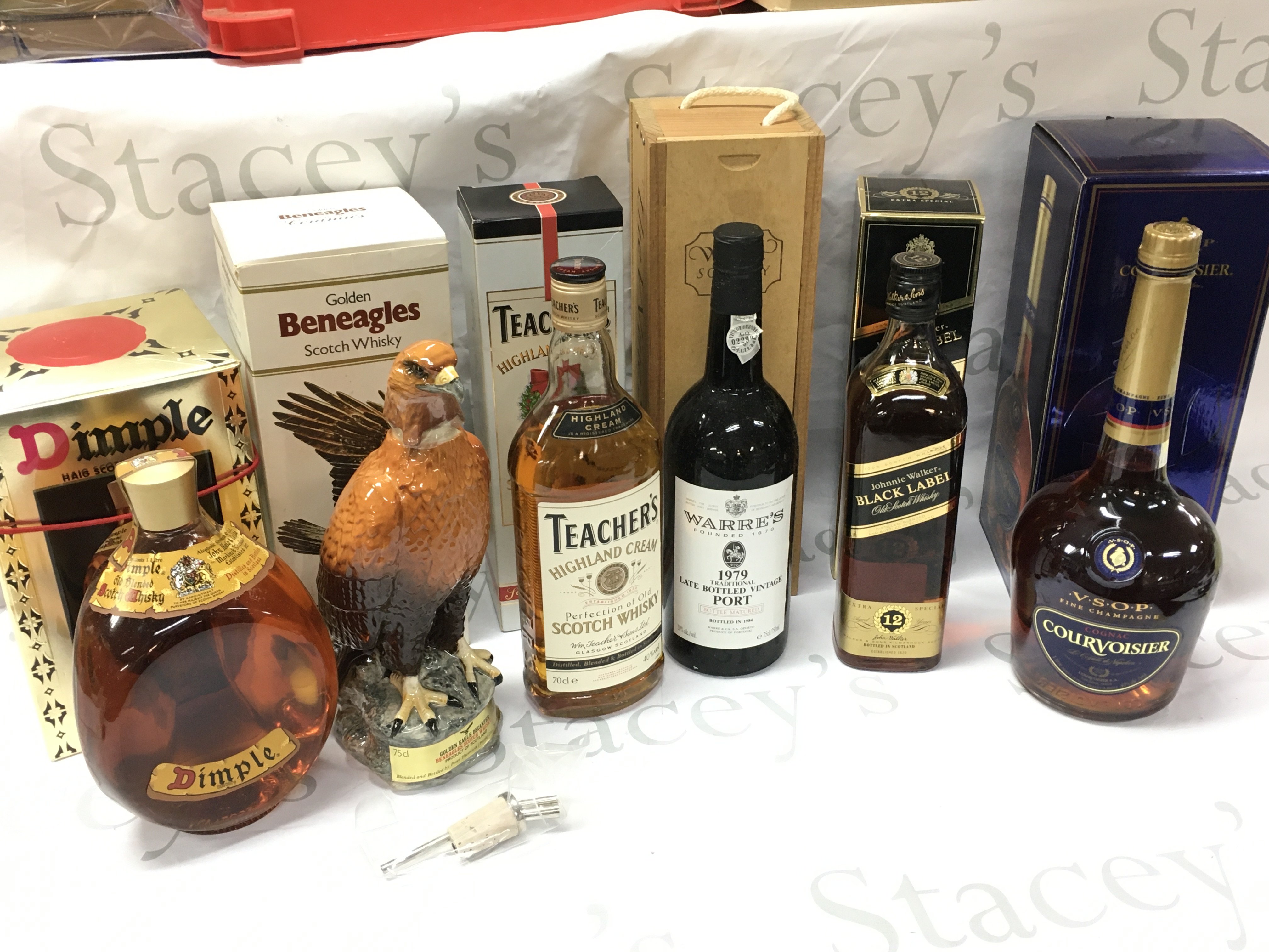 Boxed whiskeys including Dimple, Golden Beneagles scotch, Teachers highland cream scotch, Warres 1970 Late bottled vintage port, Jonnie Walker black label, VSOP COGNAC Courvoisier. This lot cannot be posted