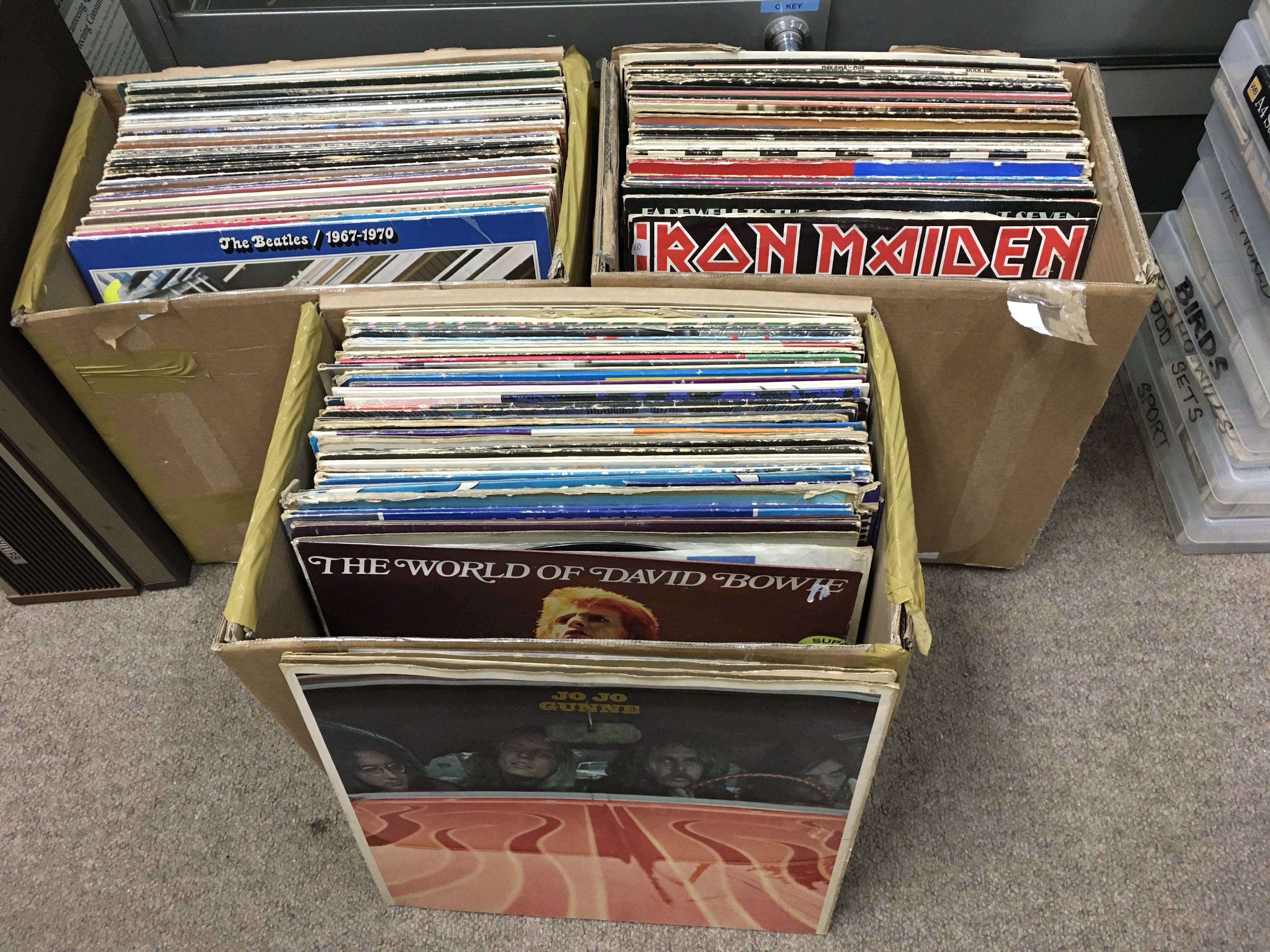 Three boxes of LPs and 12" singles by various artists including The Beatles, Queen, Iron Maiden and others. Shipping category D.