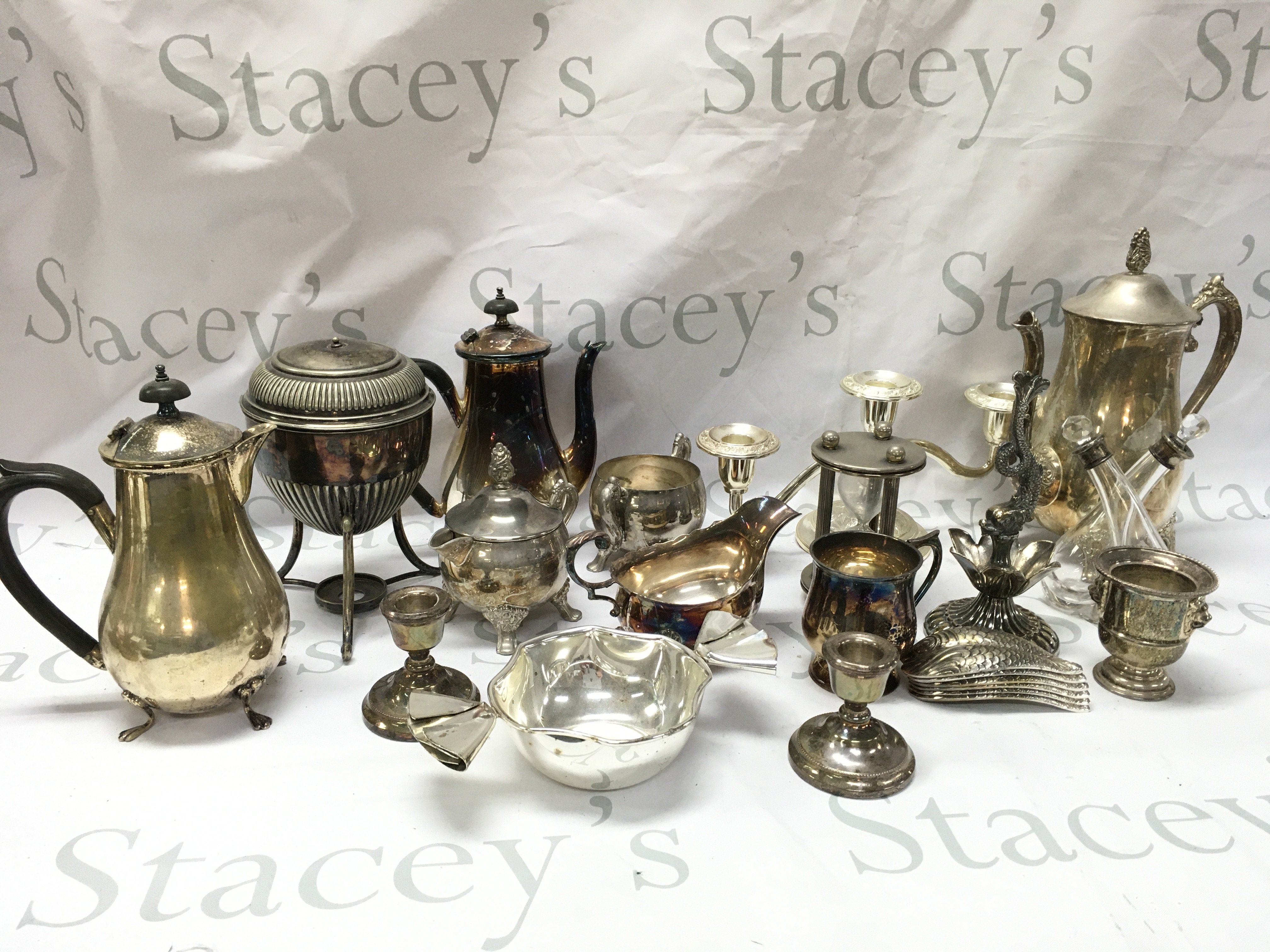 A Collection of silver plated items including jugs, candlesticks , cups , silver hallmarked collared oil and vinegar bottle etc . This lot cannot be posted