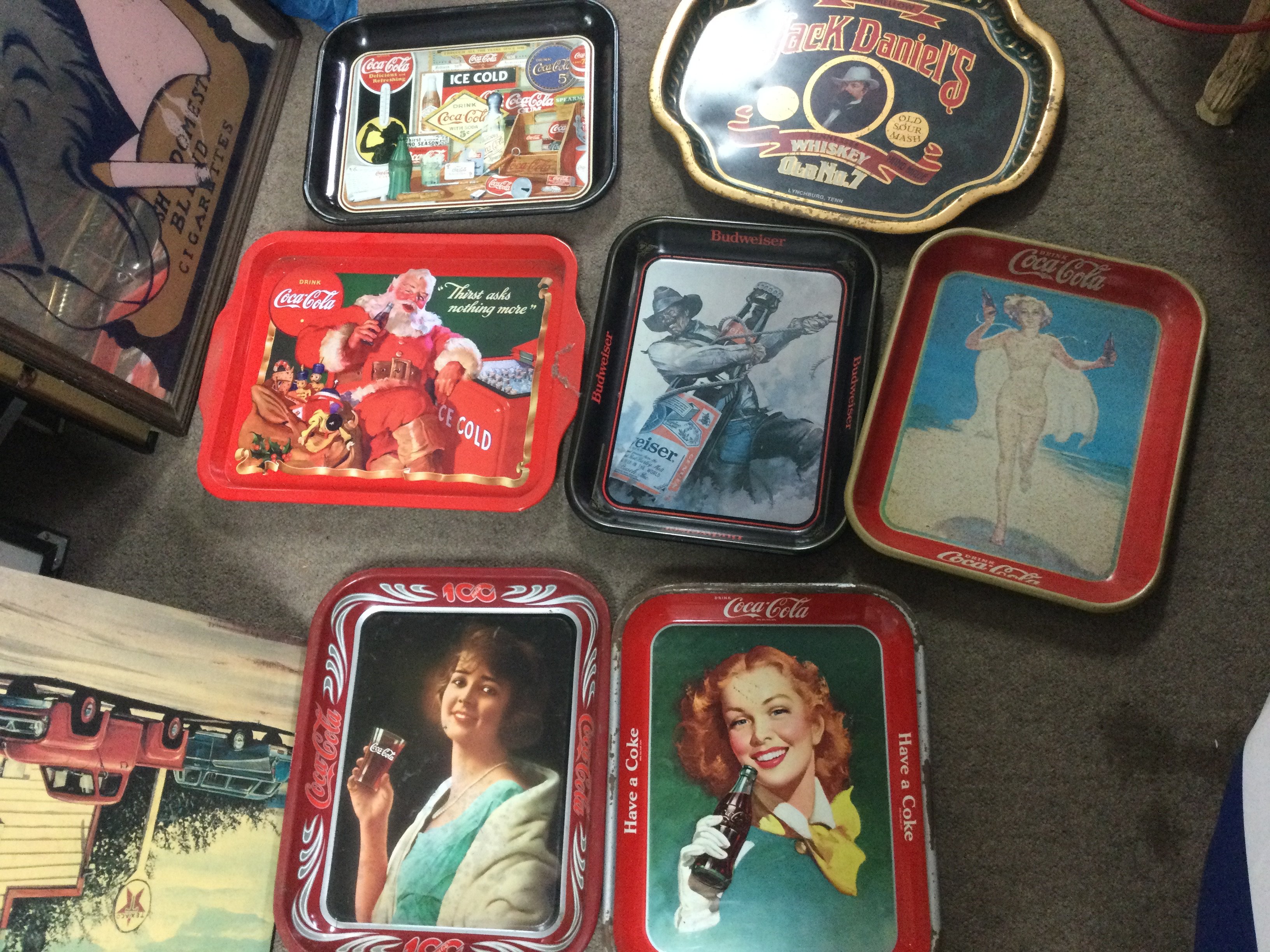 A collection of advertising trays including Coca Cola, Jack Daniels, Budweiser