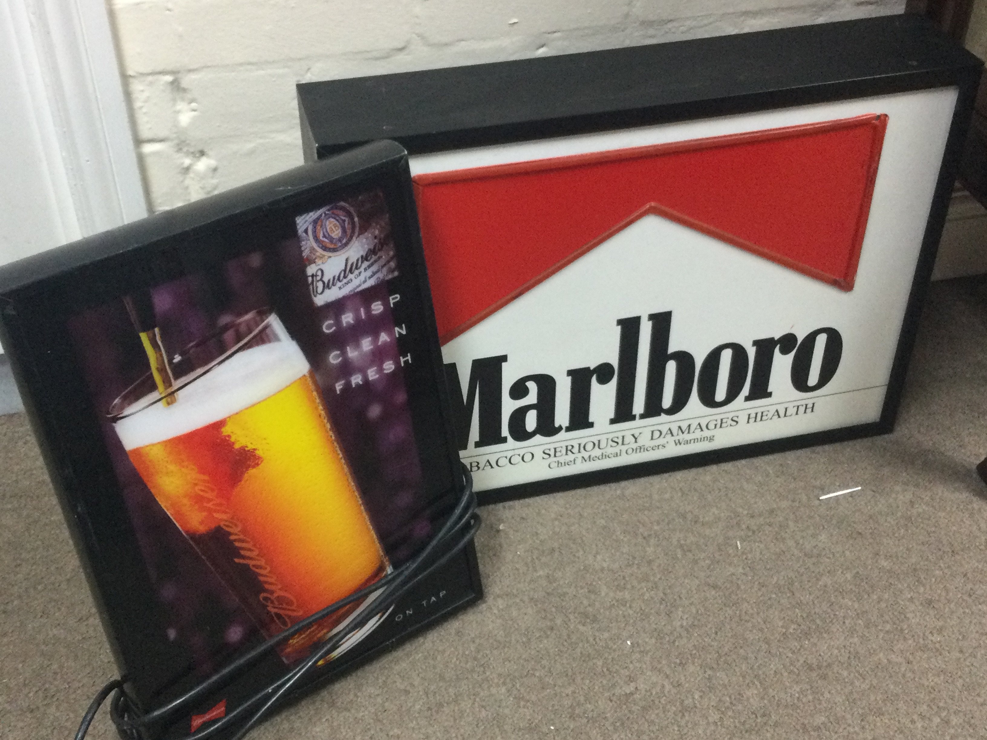 A vintage Marlboro light up sign (44cm wide 60cm tall) and a Budweiser sign (46cm tall 32cm wide) . This lot cannot be posted
