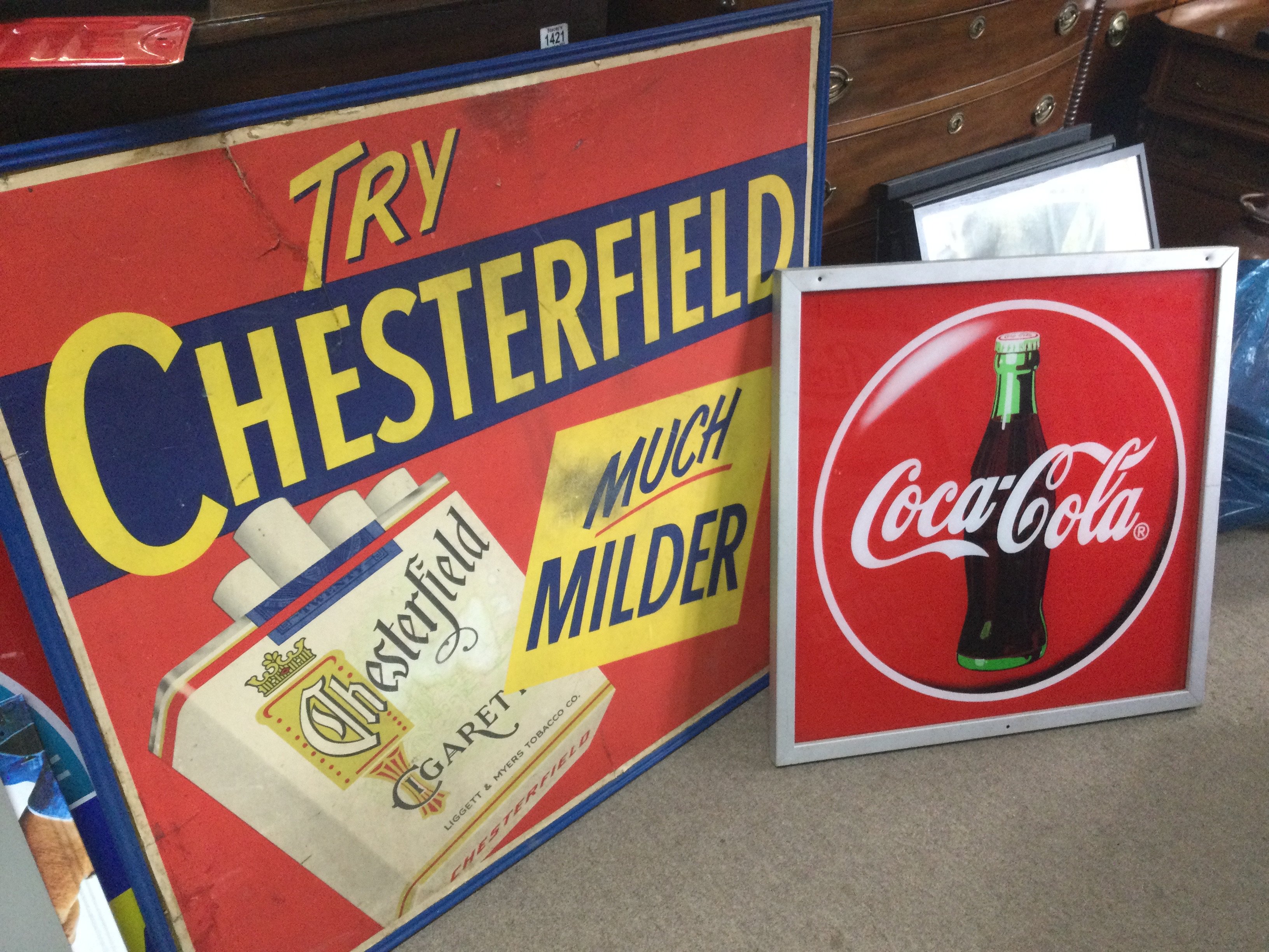 A large vintage cardboard Try Chesterfield much milder cigarette advertising sign (frame 110cm wide 105cm tall) and Coca Cola sign (75cm wide 76cm tall). This lot cannot be posted