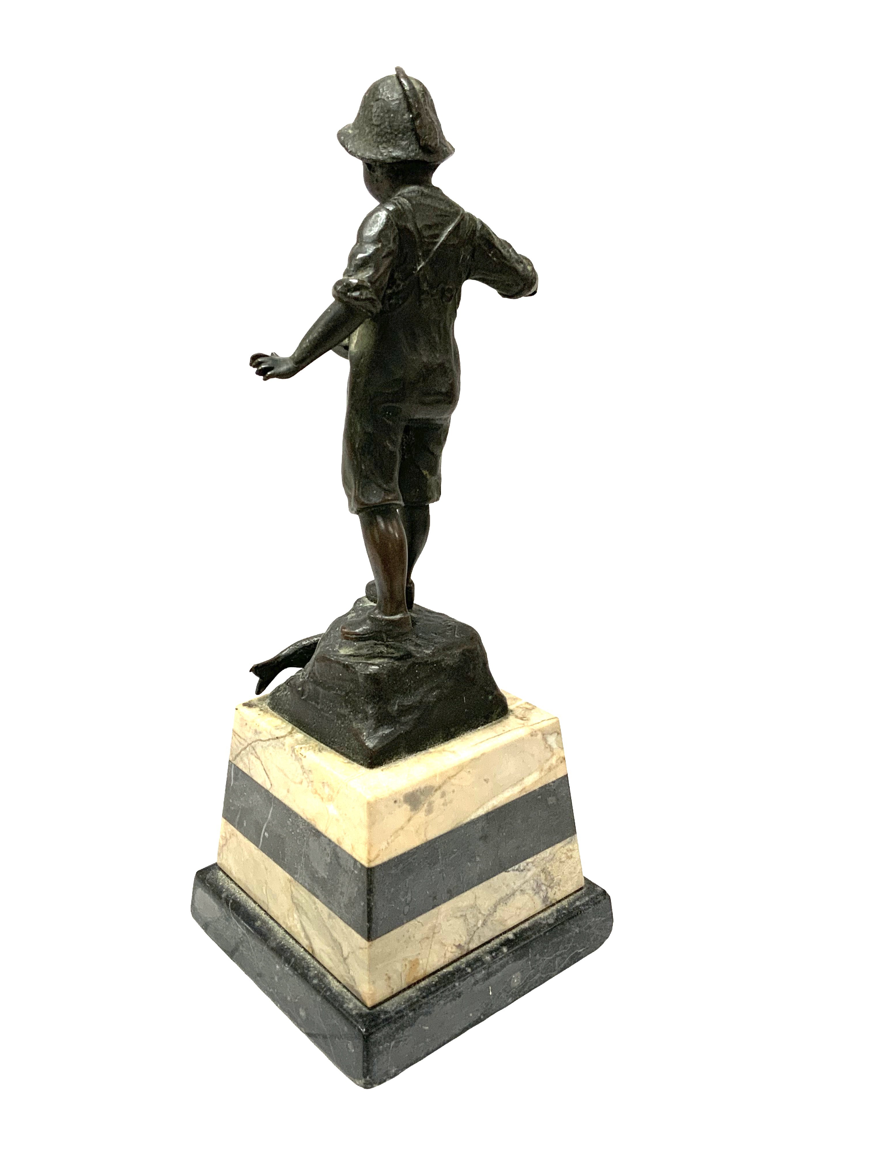 A small bronze figure of a fisher boy mounted on a marble base. 27cm.