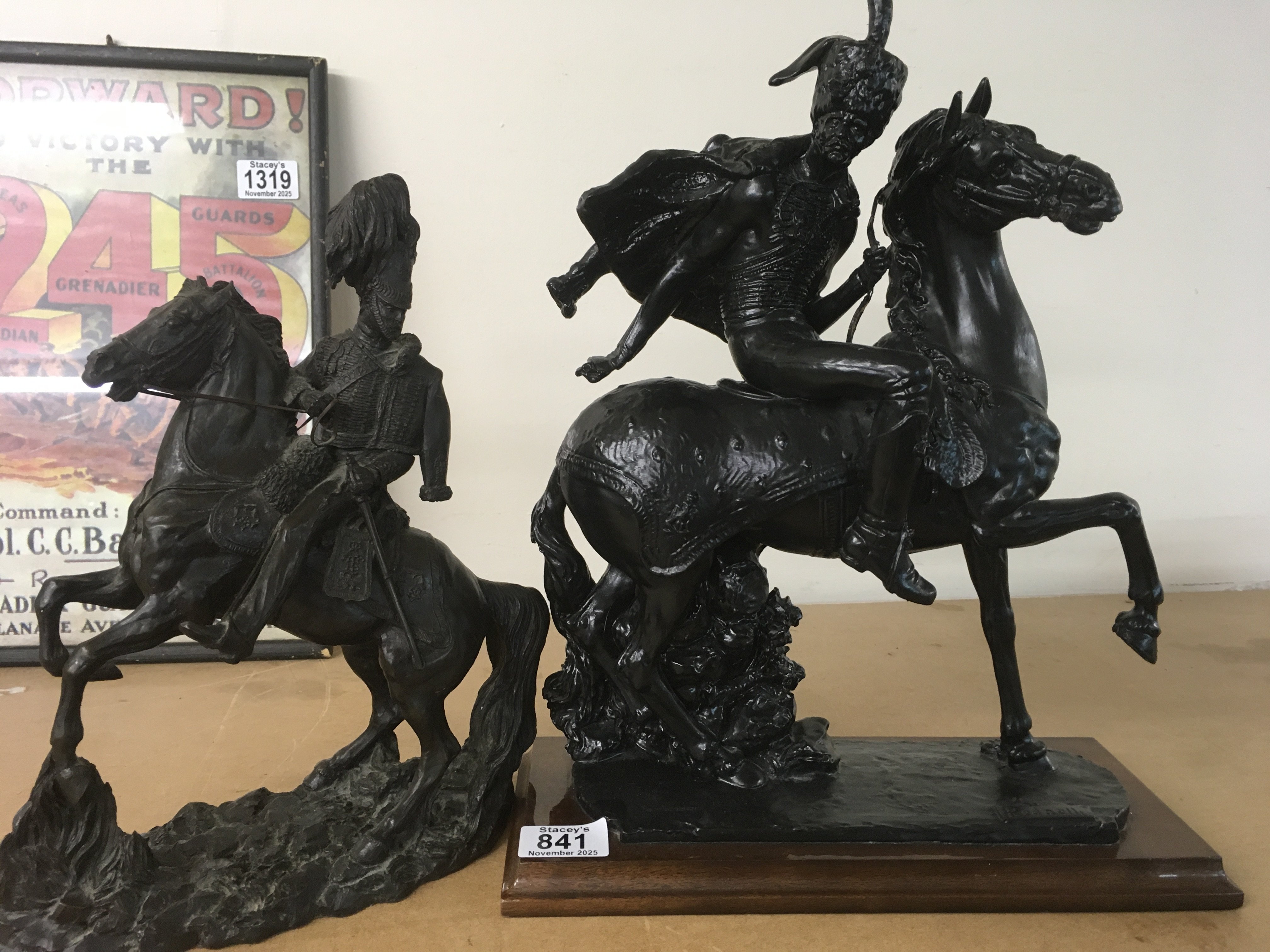 A figure in the form of a Hussar cavalry officer on horseback together with One other figure on horseback on a plinth base .