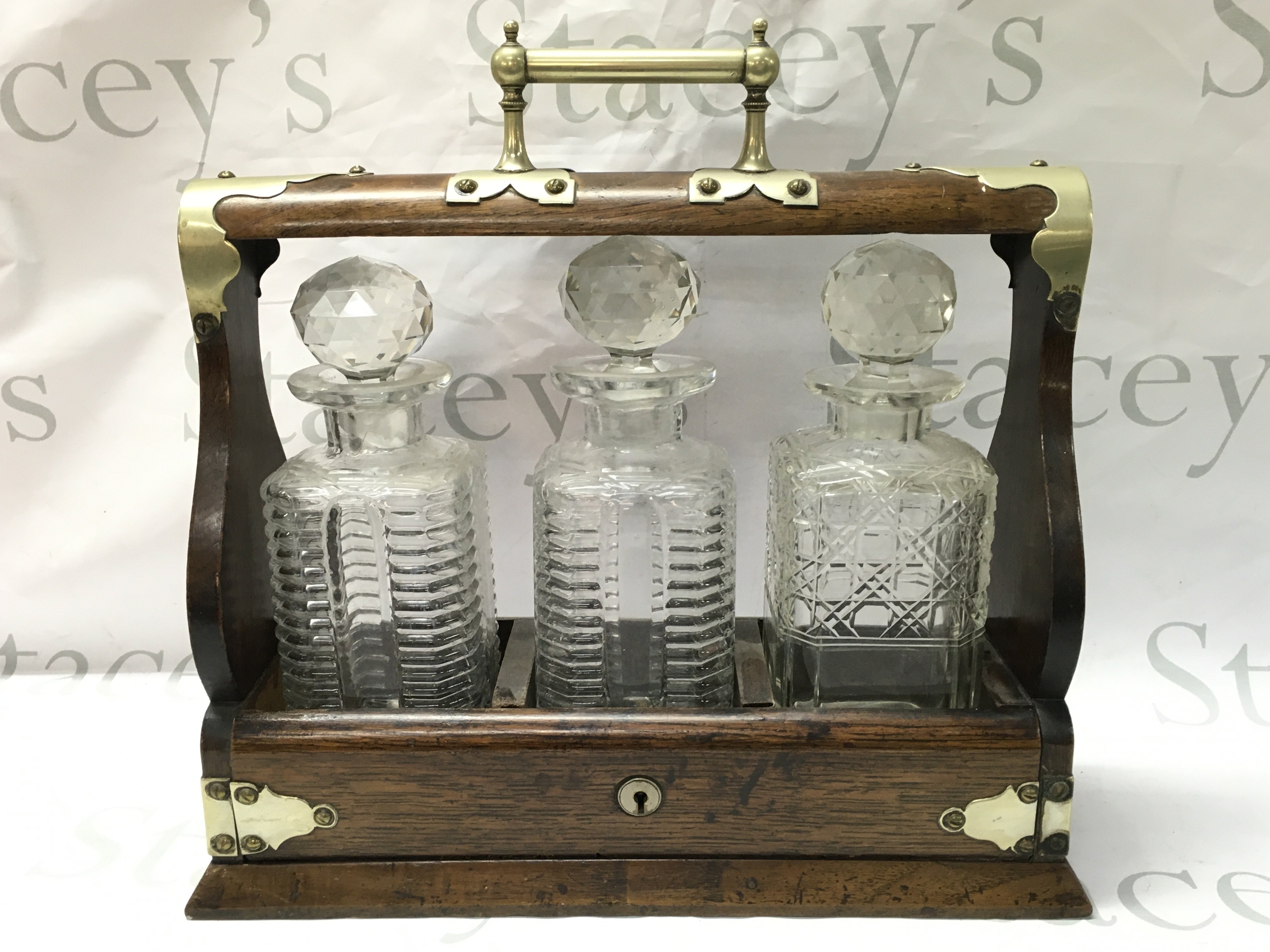 An oak and silver plated three glass decanter tantalus ,37cm wide 35cm tall. This lot cannot be posted