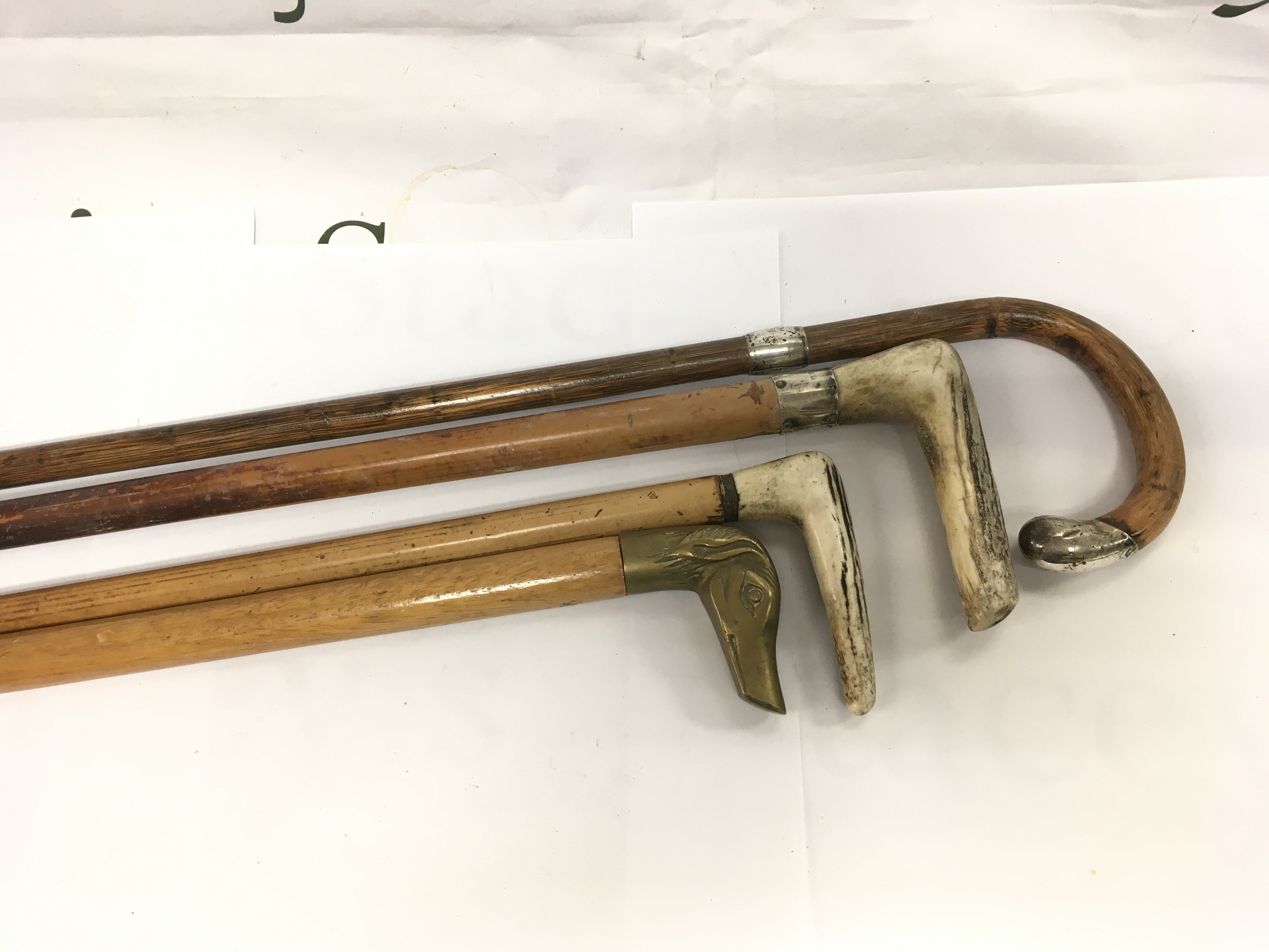 Four walking sticks including two with silver bands. Shipping category D.