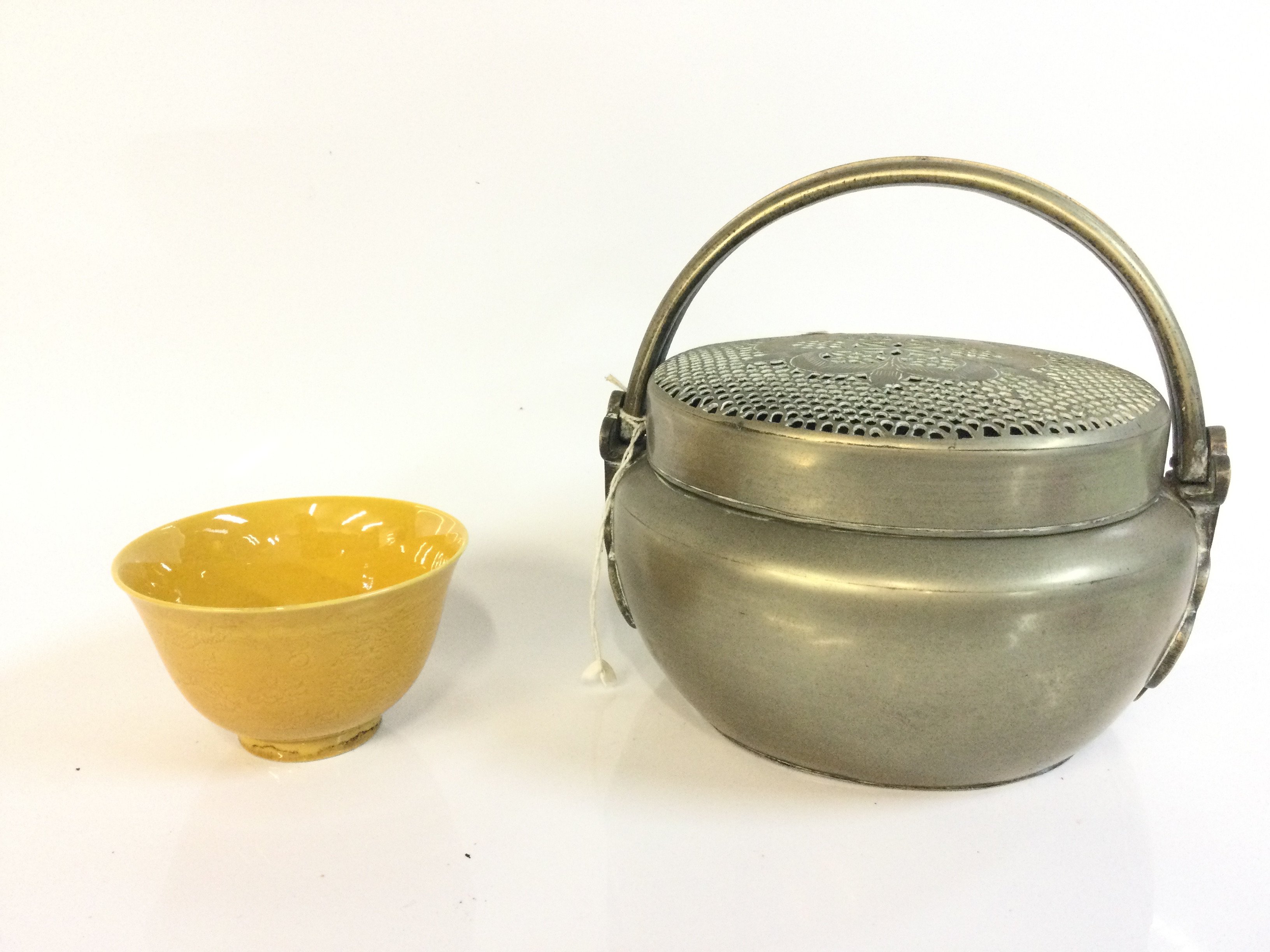 A Chinese hand warmer and a yellow glaze bowl. 5 and 15 cm tall. This lot cannot be posted