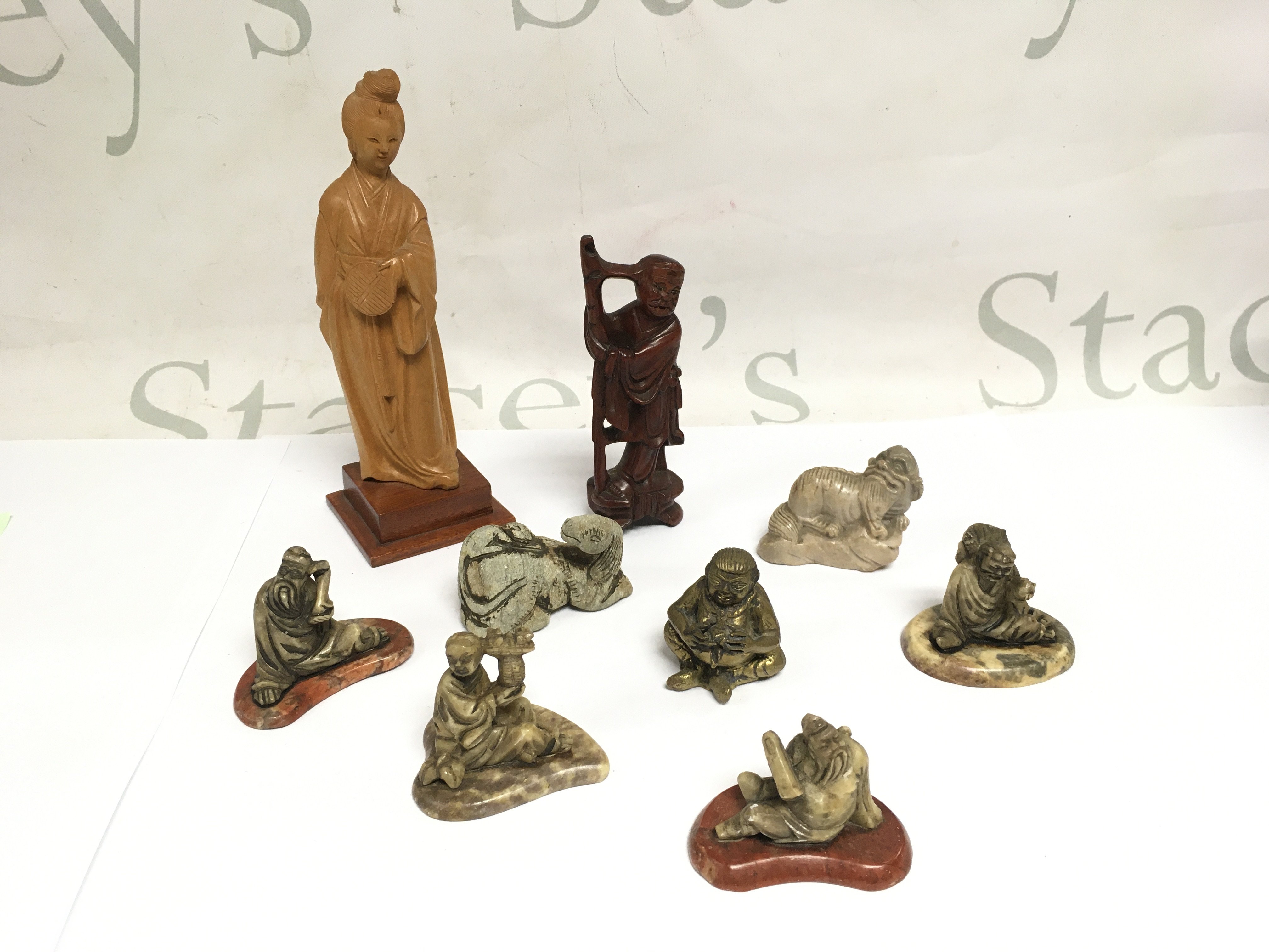 A collection of miniature Oriental figures comprising carved hardstone examples and others. Shipping category B.