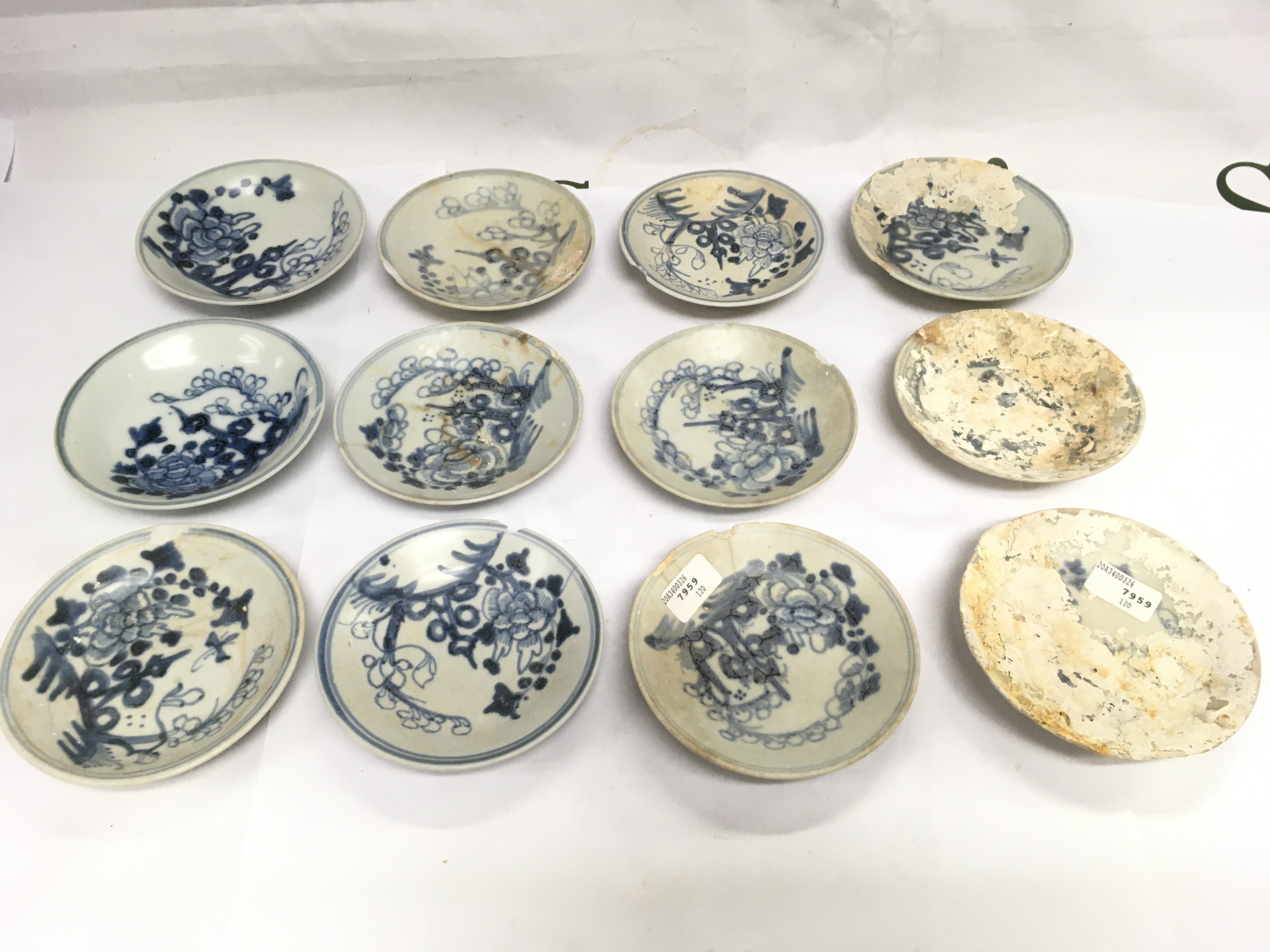 Twelve small Tek Sing blue and white dishes, approx diameter 10.5cm. Some damages. Shipping category D.