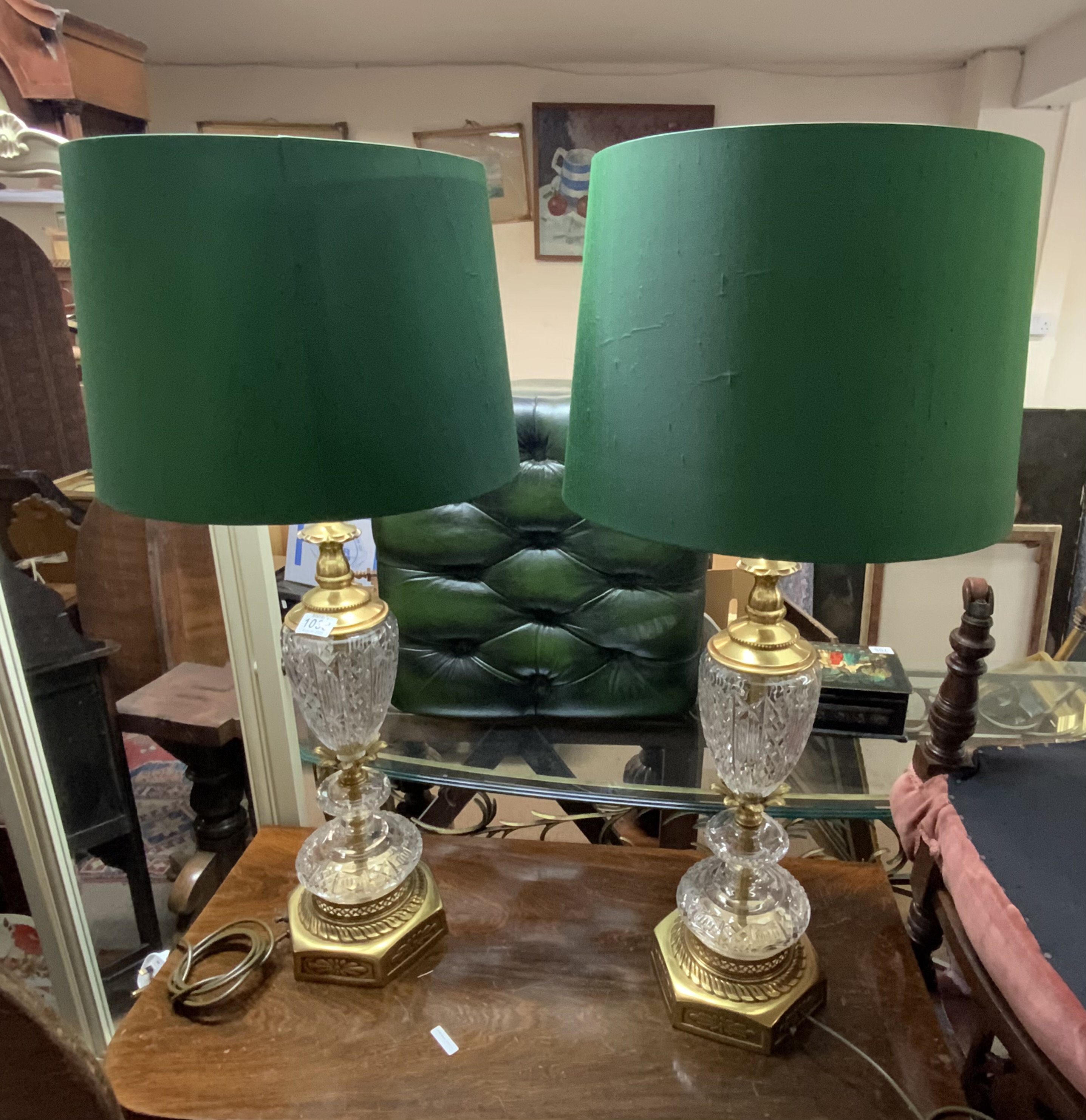 A large pair of cut crystal and gilt brass table lamps. With matching green shades. 65cm ( 85cm with shades)