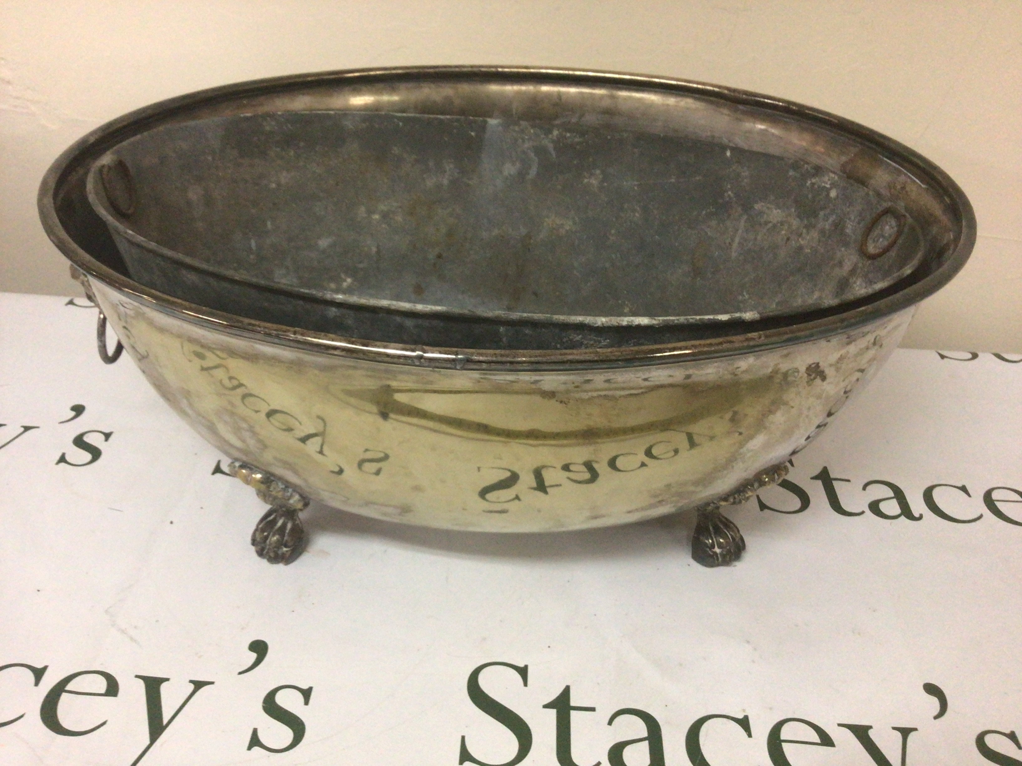 A 19th century Continental brass wine cooler the sides with lion masks and claw feet a set of fire irons and one other silver plated cooler with detachable liner. 59cm