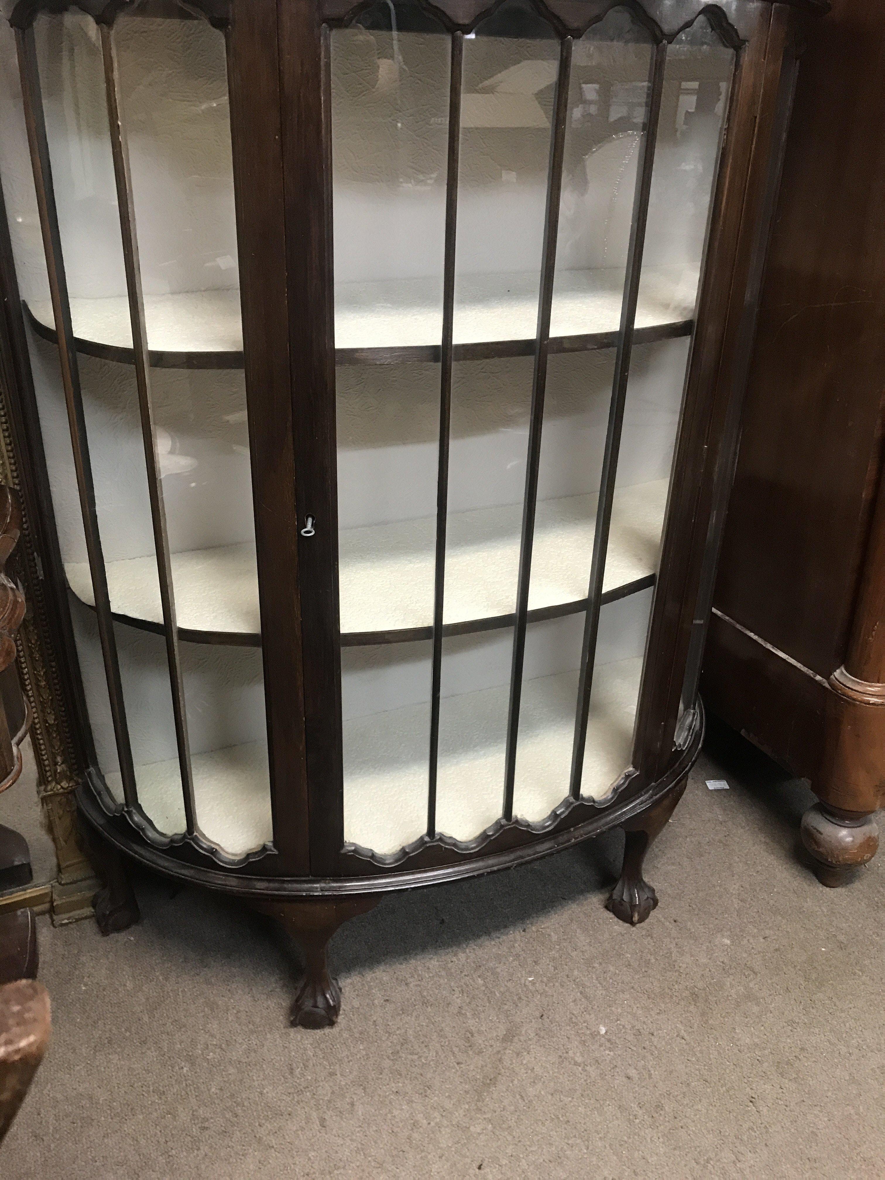 A mahogany semi circular display cabinet on ball and claw feet. 140cm x 138cm