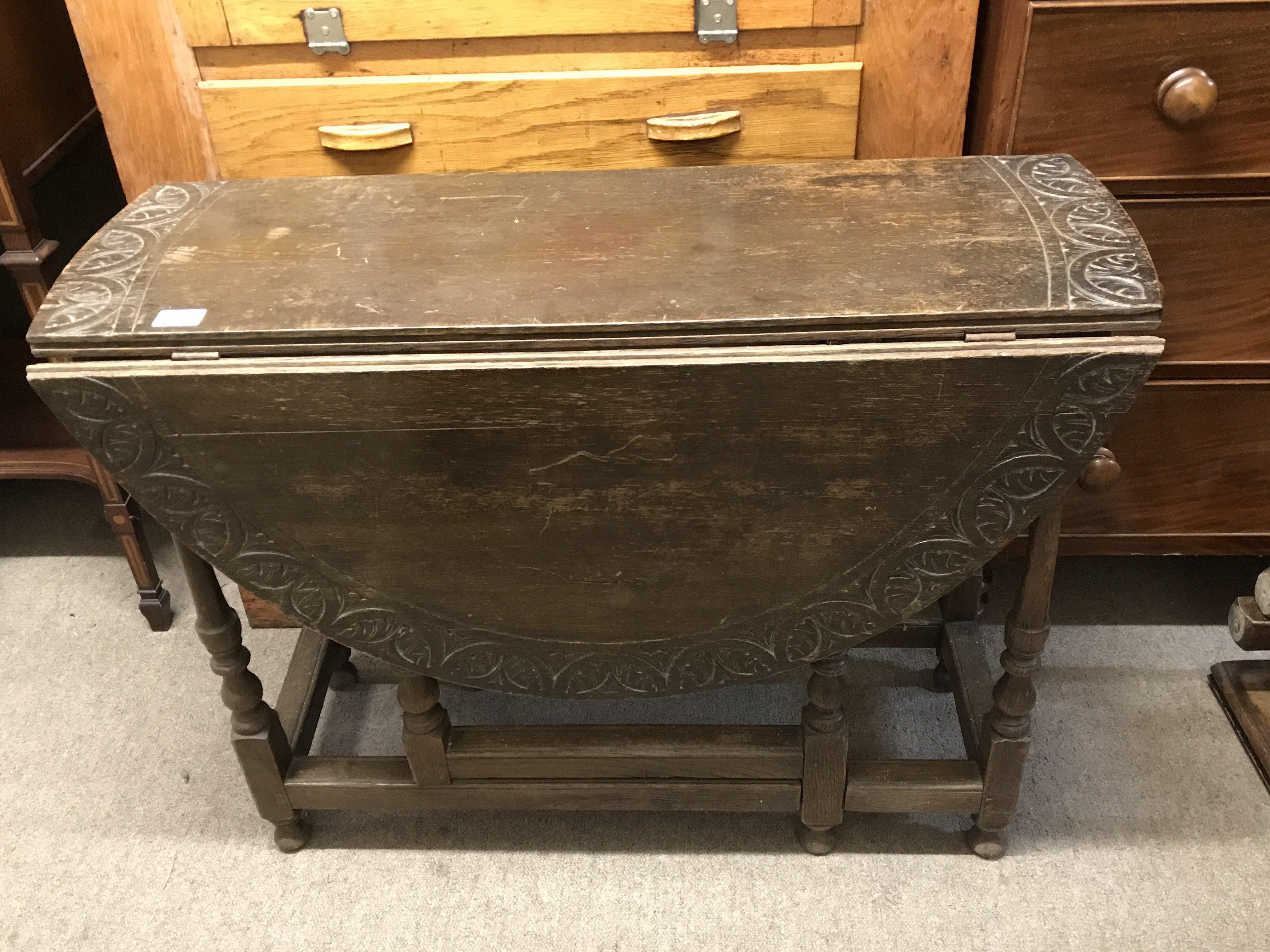 A carved oak drop leaf circular table. No Reserve.
