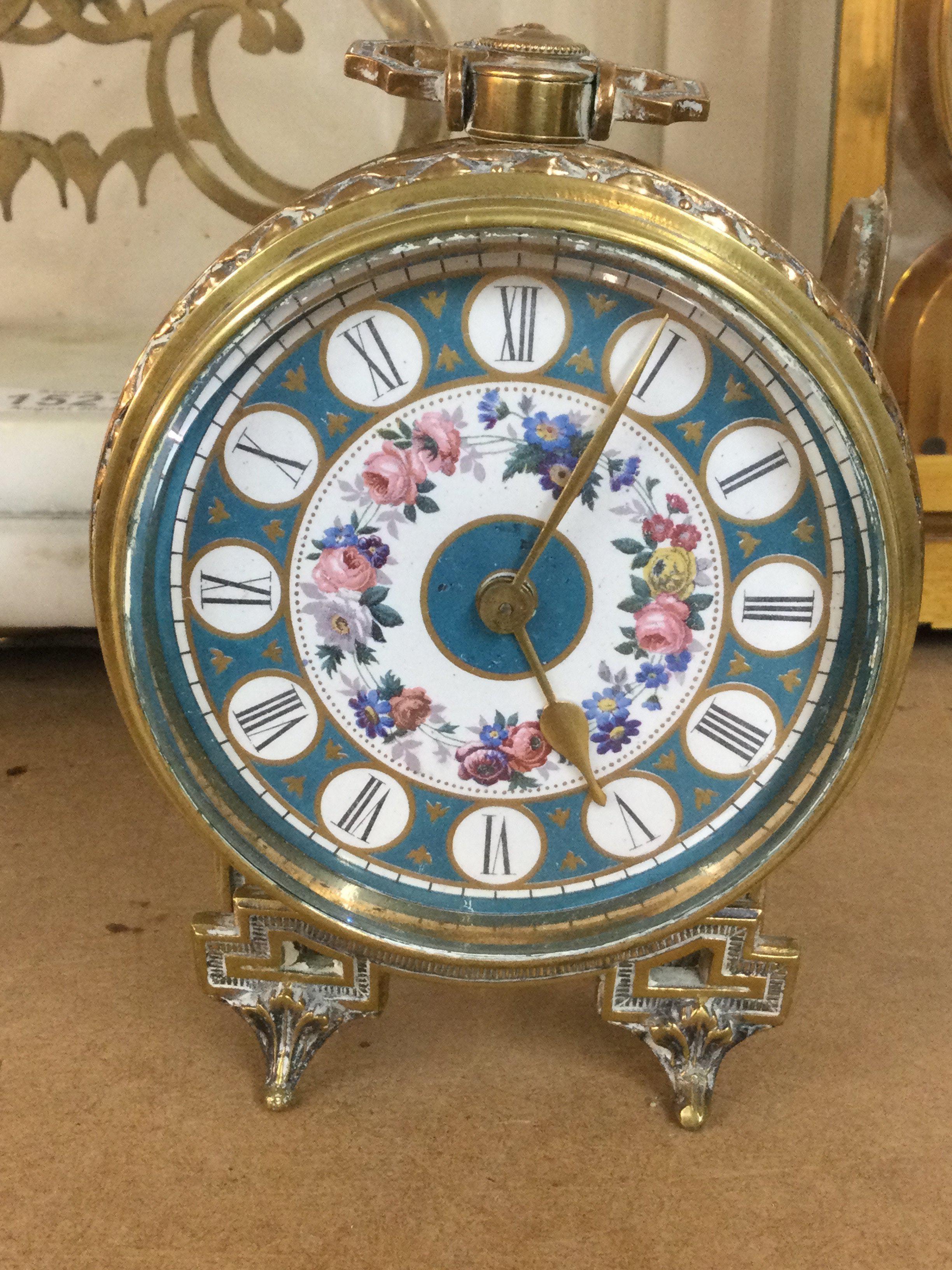 A French bedside clock the enamel dial with Roman numerals.