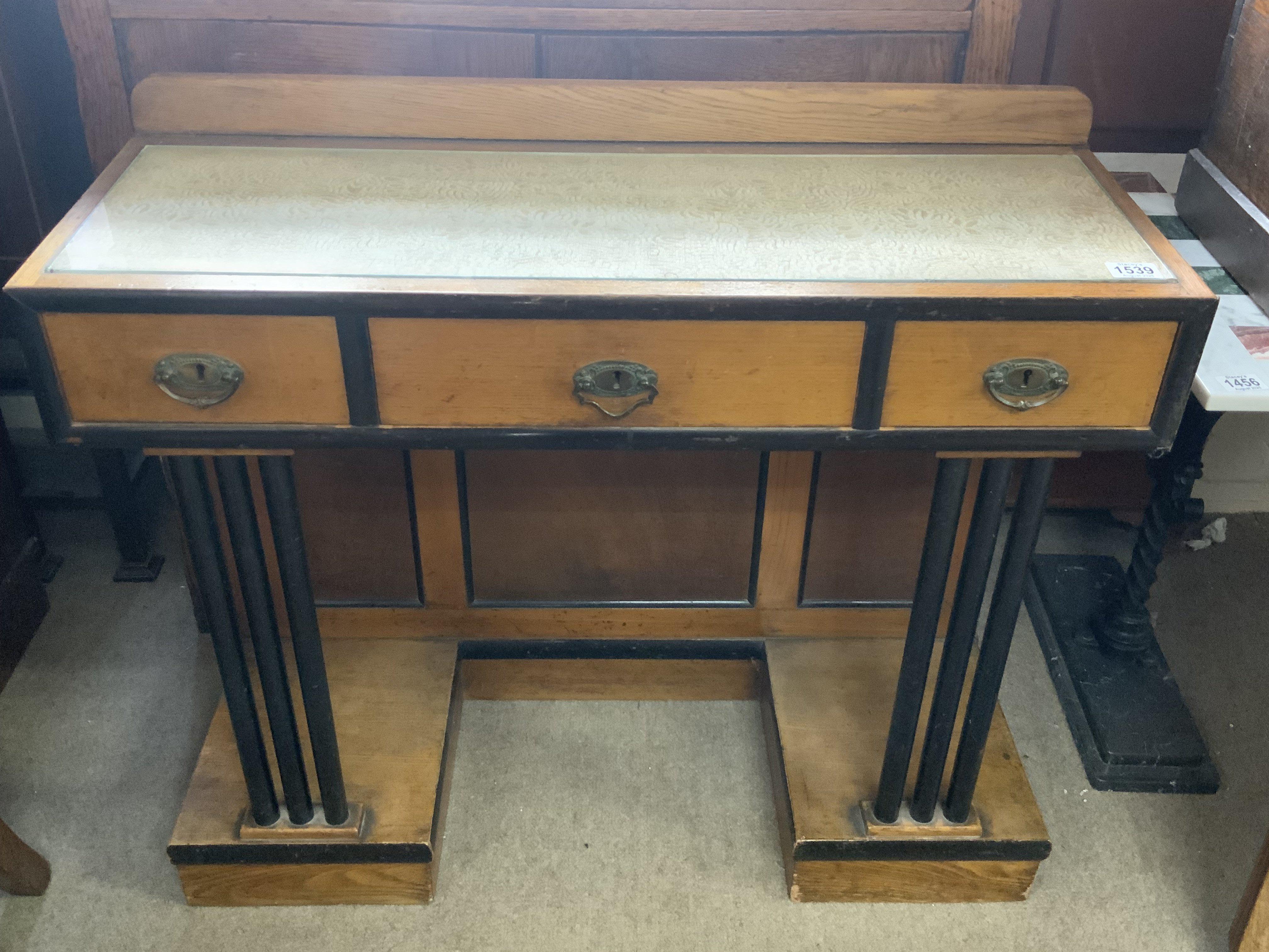 A small golden oak art deco hall table with ebonized pillars and draw frames. 90cm x 34.5cm x 79cm
