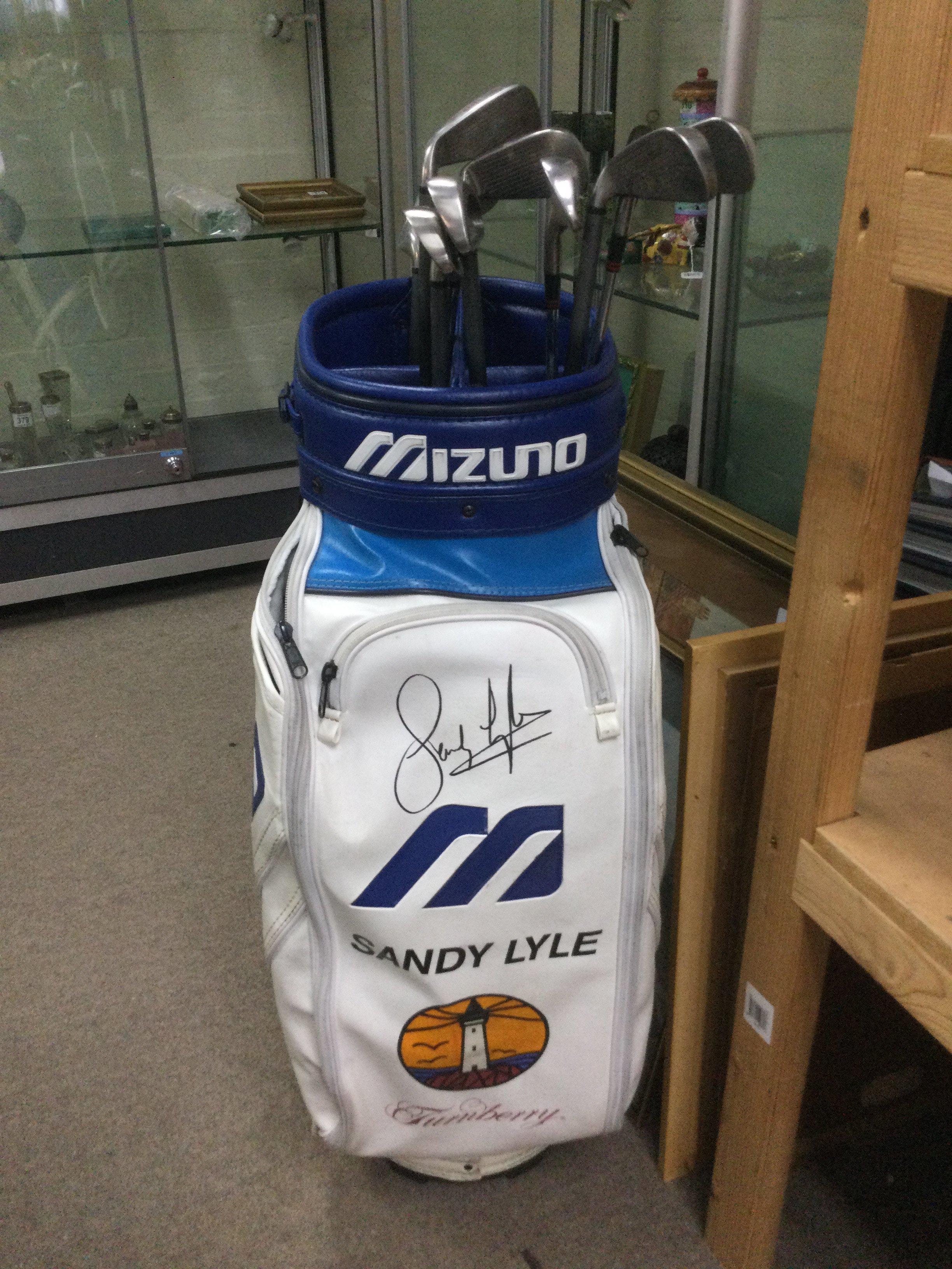 A golf bag signed by Sandy Lyle and containing various clubs plus three more golf related items signed by Sandy (4).