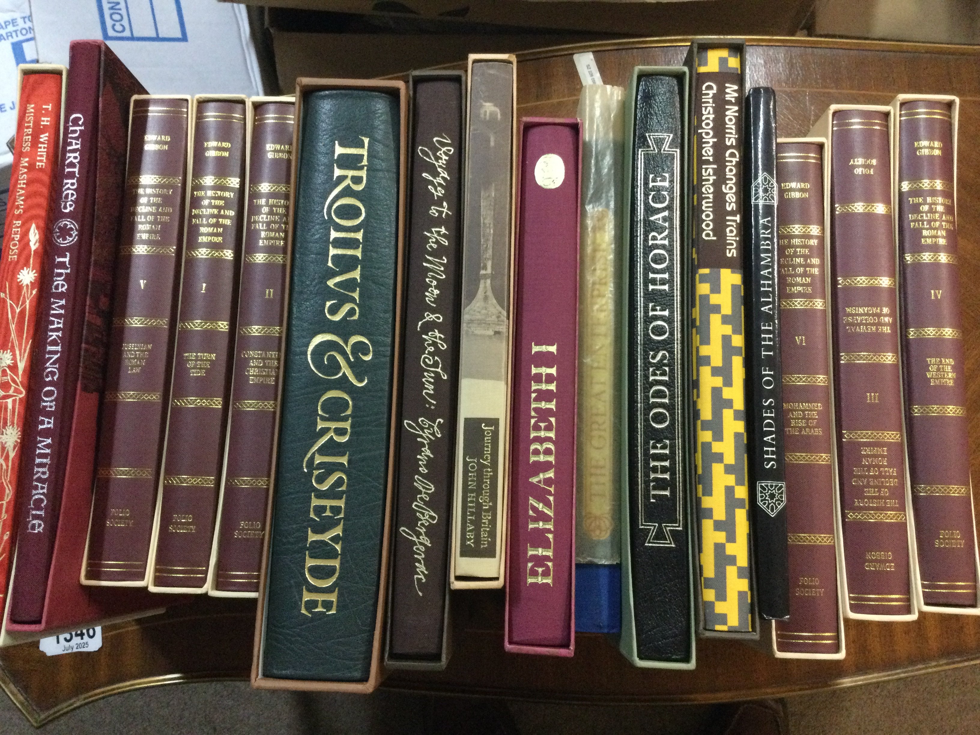 A box containing books including folio Society.