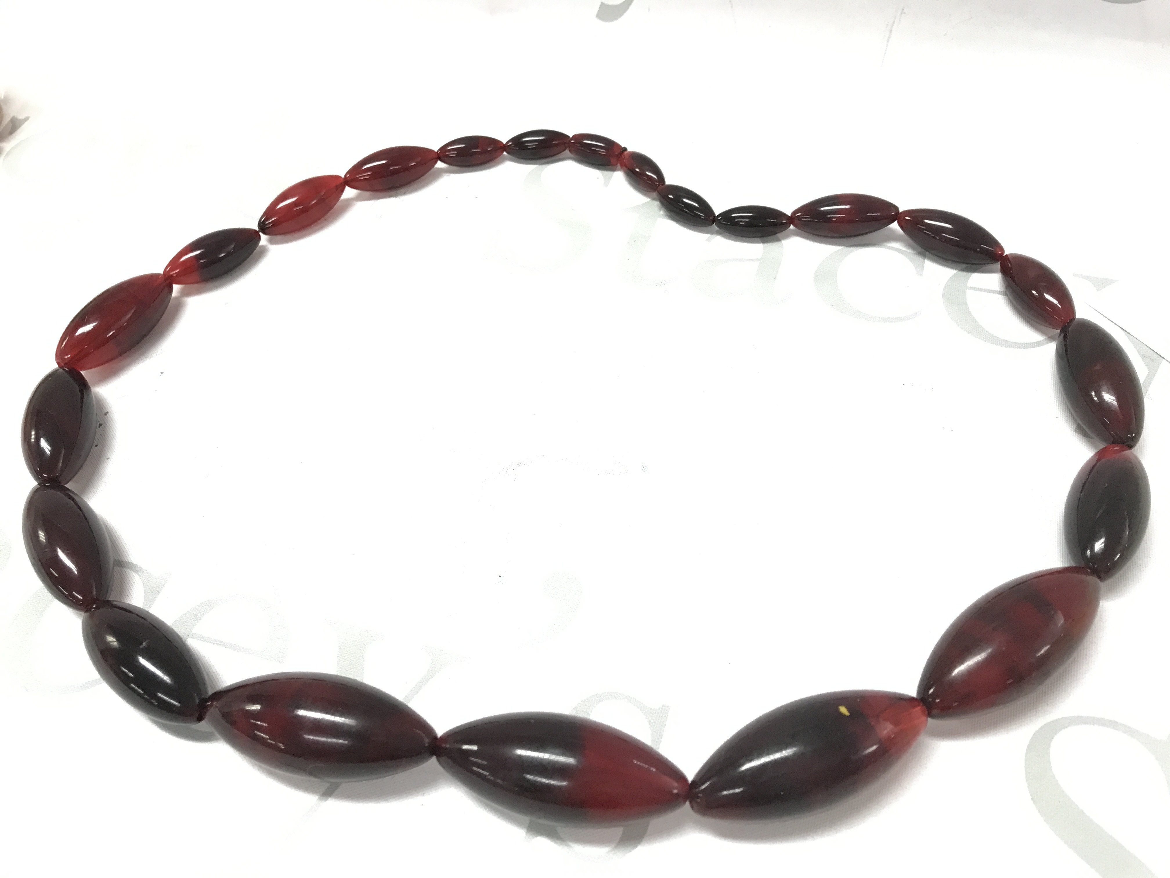 A large cherry amber style lucite necklace , 155g total weight 80cm . Postage category A