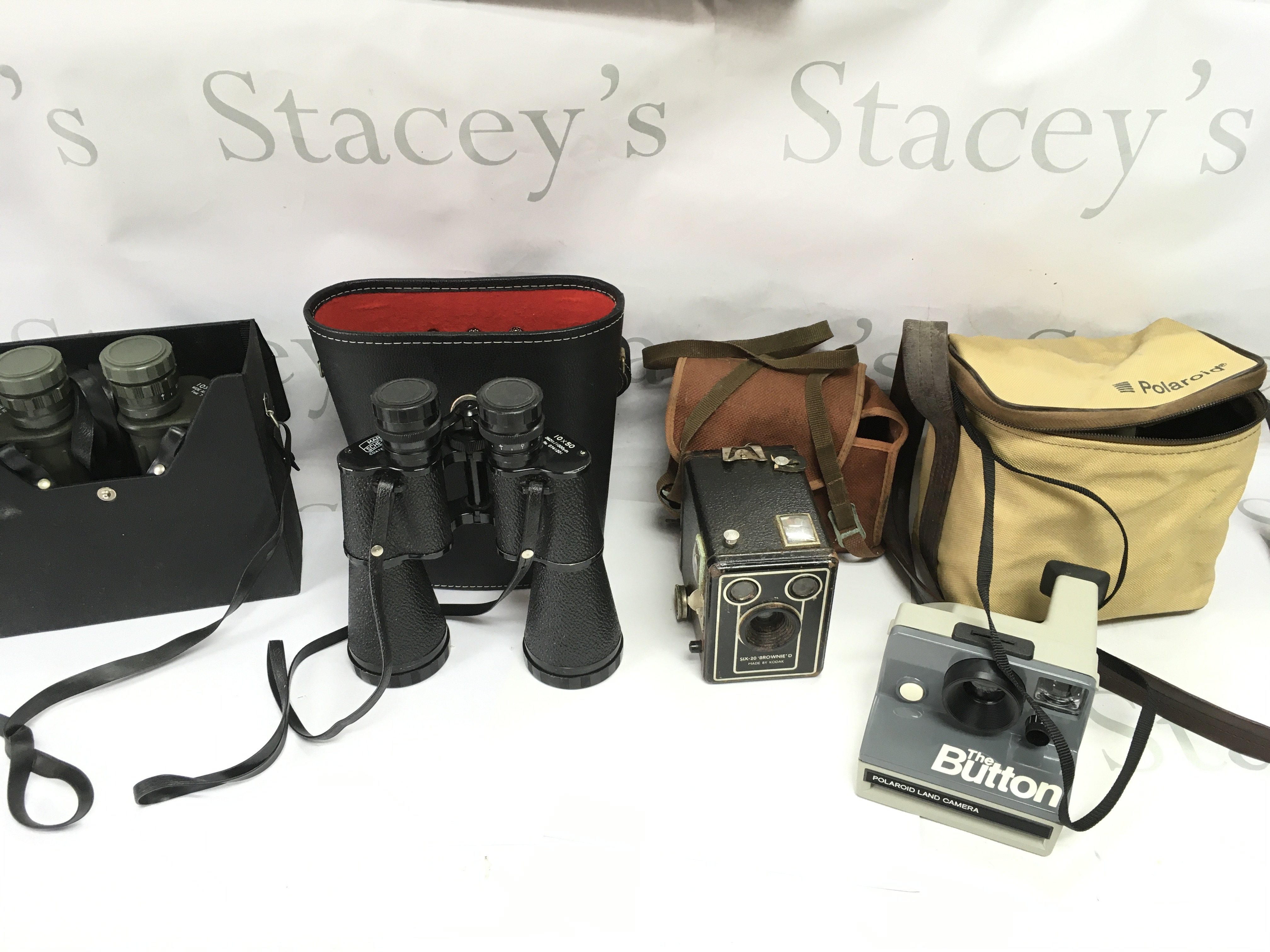 Two sets of binoculars and two vintage cameras including a Kodak Brownie and a Polaroid. Postage B