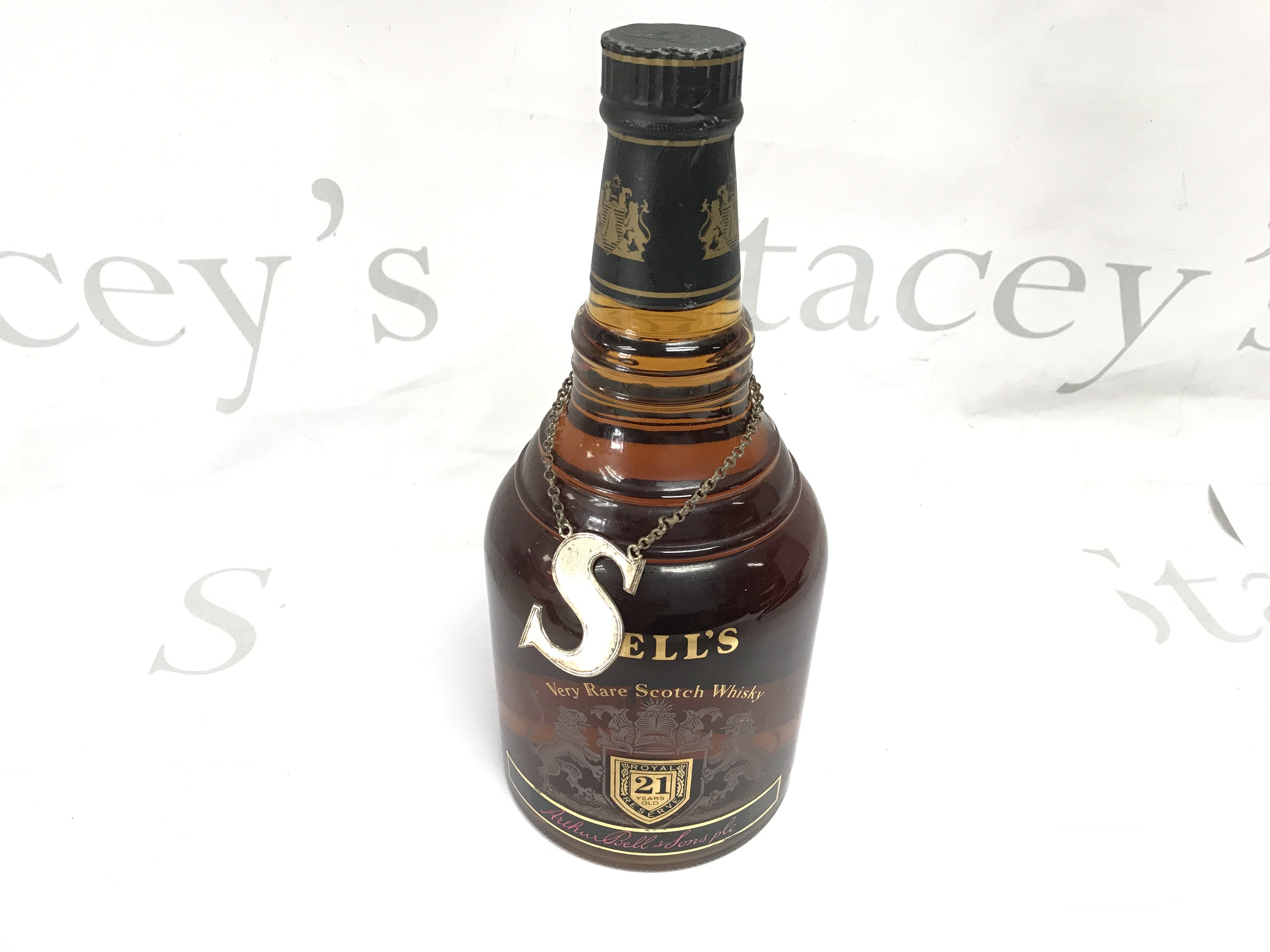 A bottle of bells 21 year old rare scotch whiskey with a silver label.