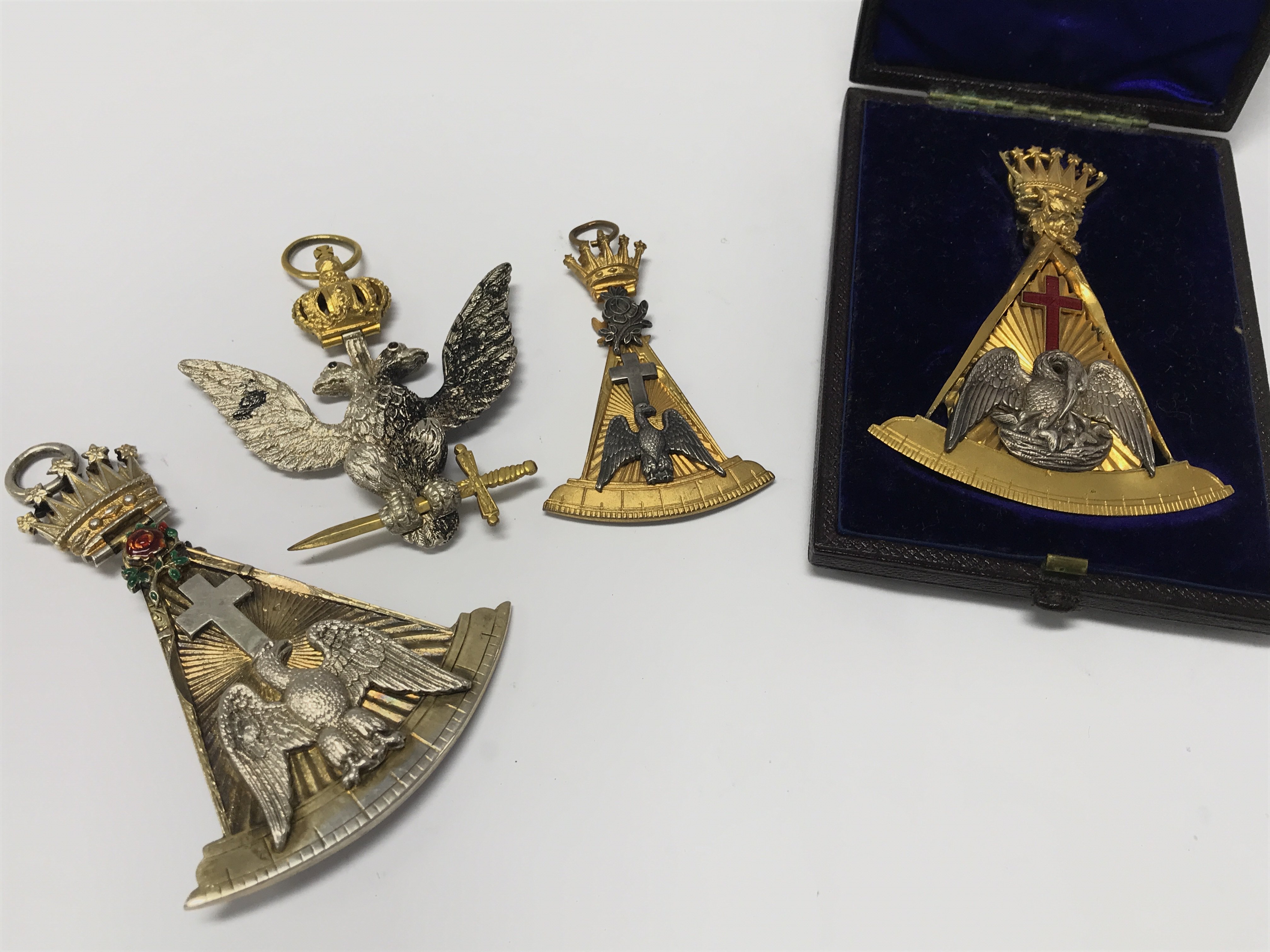 A cased gilt metal Masonic Regalia Rose Croix 18th degree jewel maker Joseph Strakley in a fitted case a similar silver rose Croix a 32nd degree eagle the reverse with date 1873 and one other Croix. Postage category A